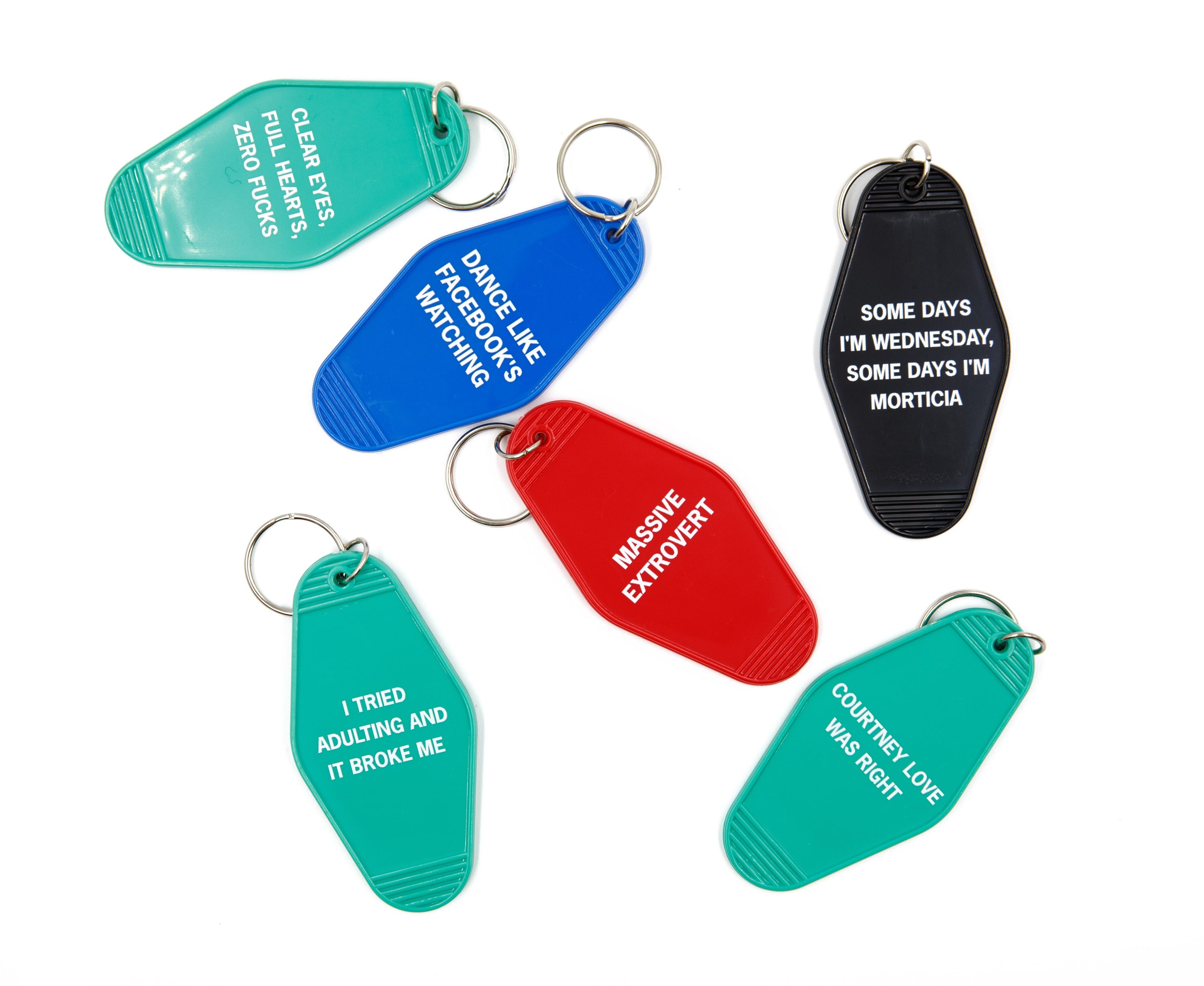 A vibrant red keychain with the words 'Massive Extrovert' in bold white lettering, featuring a classic motel key tag design.