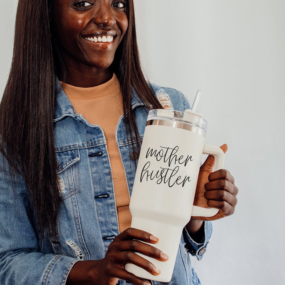 Mother Hustler 40oz tumbler with matte finish, featuring a bold black graphic on a cream exterior, designed for busy moms.