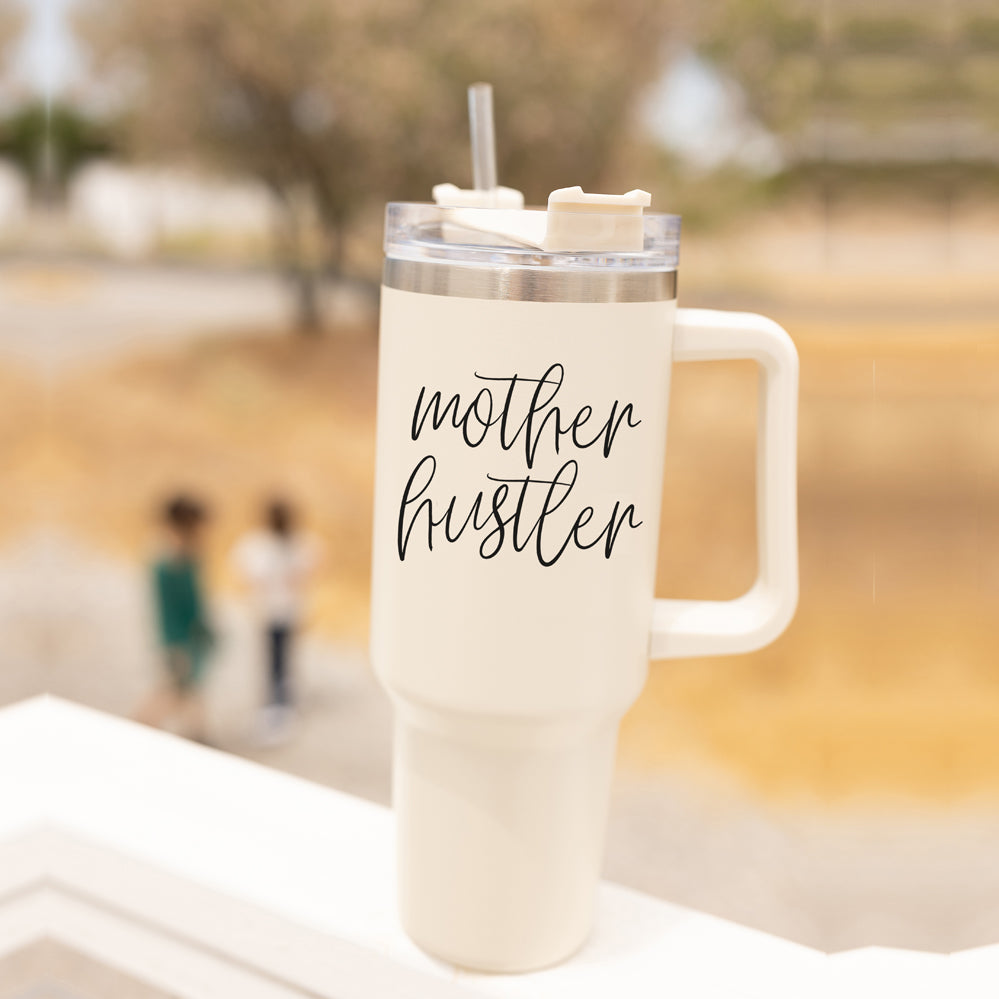 Mother Hustler 40oz tumbler with matte finish, featuring a bold black graphic on a cream exterior, designed for busy moms.