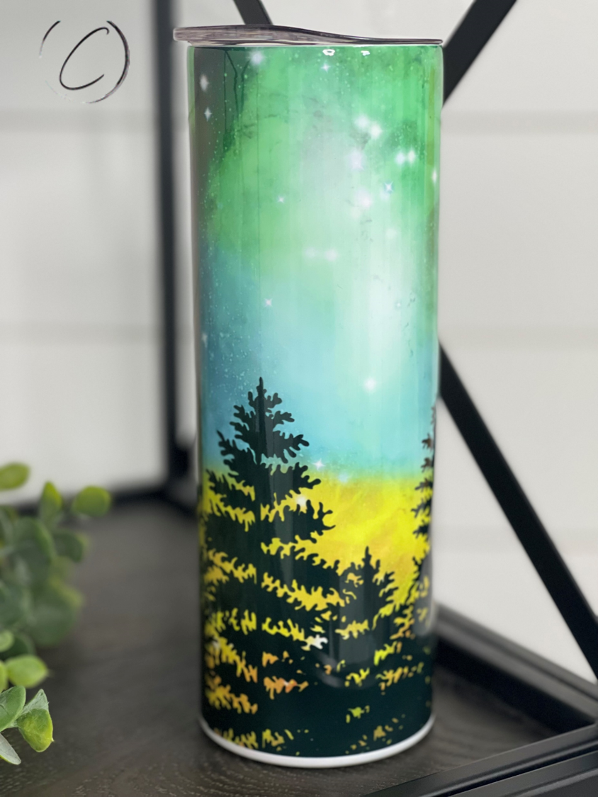 A 20oz skinny tumbler featuring a vibrant Northern Lights design, showcasing beautiful colors and a sleek shape, perfect for hot and cold beverages.