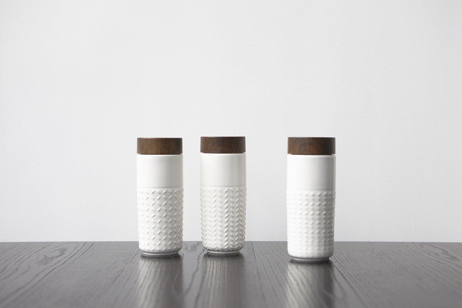 One-O-One Dreamy Starry Sky Ceramic Tumbler showcasing its embossed checkered design and walnut wood-effect lid in various trendy colors.