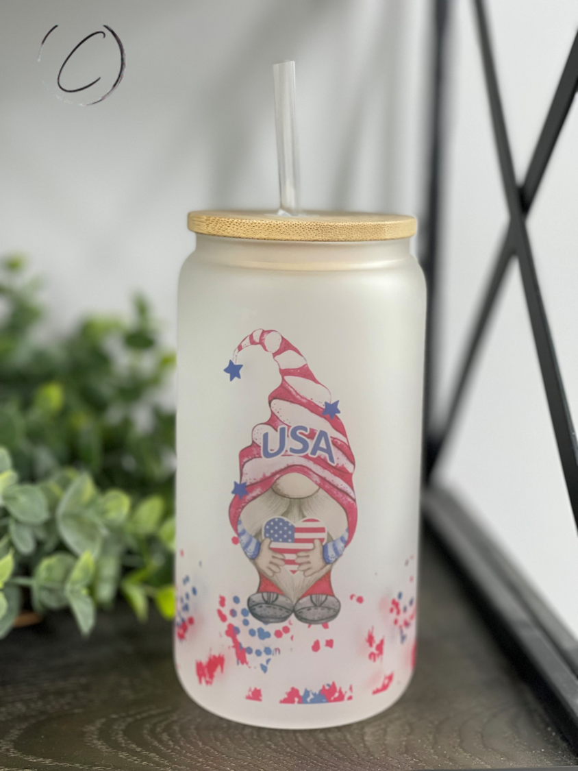 A 16oz Libbey glass tumbler featuring a colorful patriotic gnome design, complete with a reusable straw.