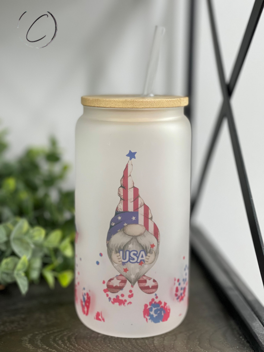 A 16oz Libbey glass tumbler featuring a colorful patriotic gnome design, complete with a reusable straw.