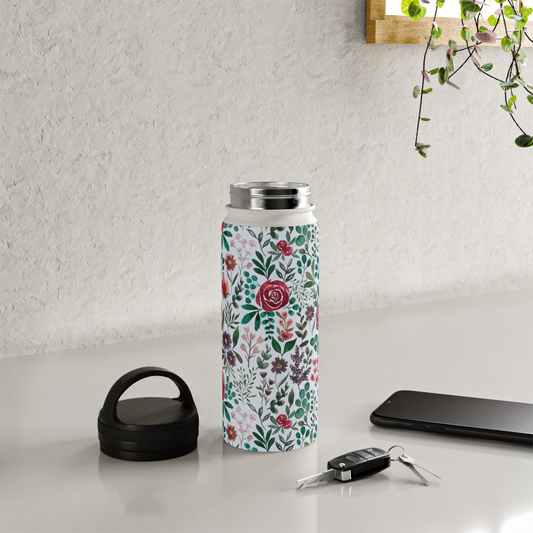 Pink and purple floral stainless steel water bottle with handle lid, showcasing its stylish design and durable construction.