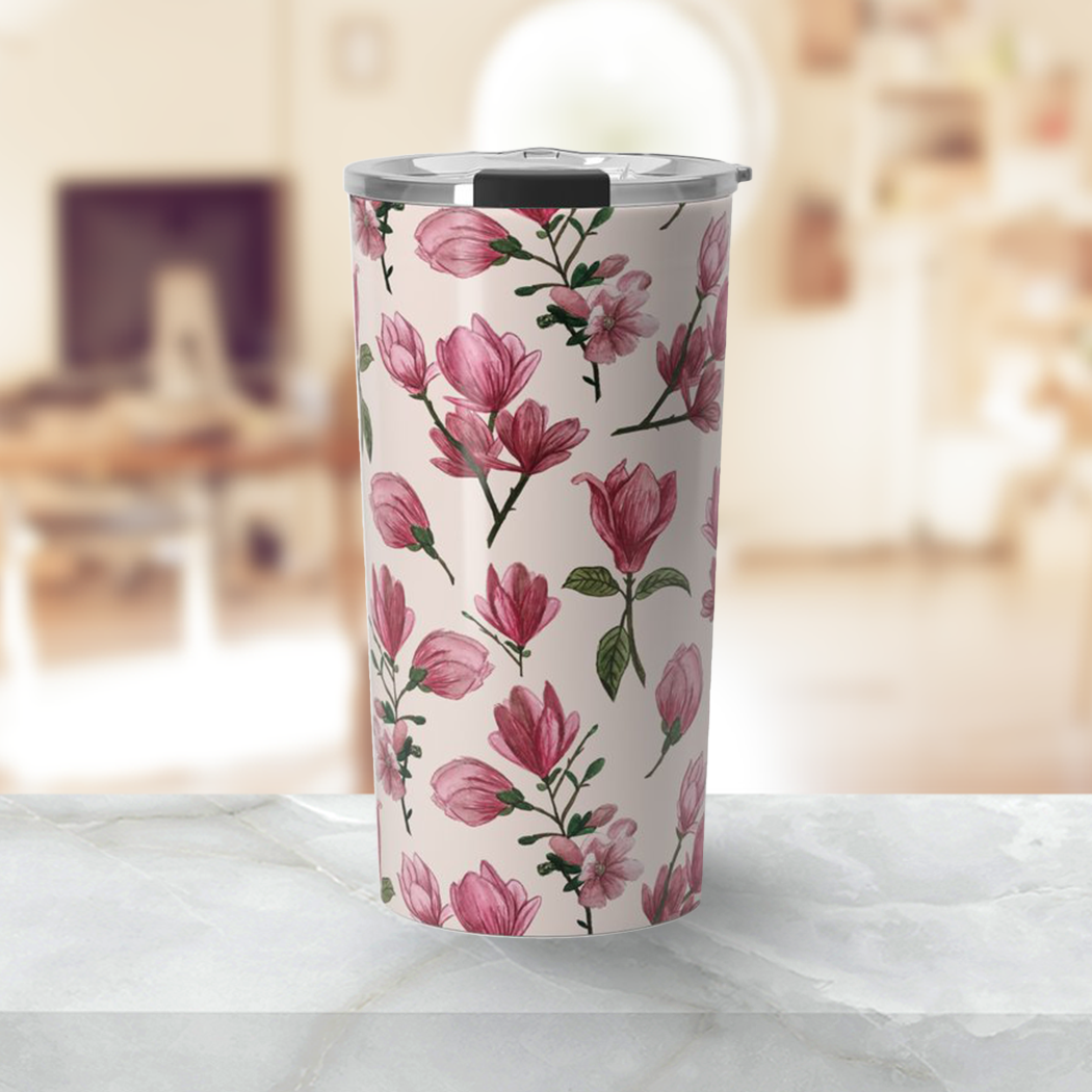 A stylish Pink Magnolia Blossom Travel Mug made of stainless steel with floral design, perfect for hot or cold beverages.