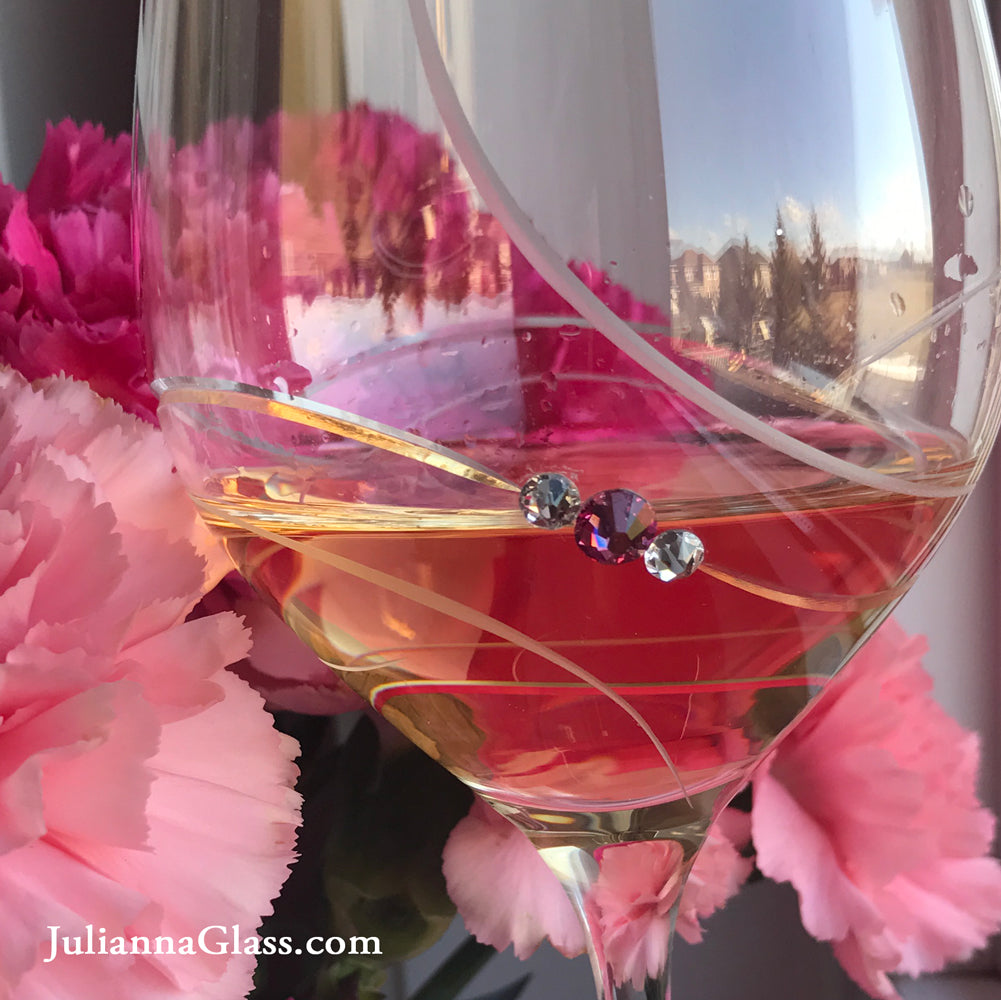 Set of two elegant pink ribbon red wine glasses with Swarovski crystals in a gift box, showcasing handcrafted lead-free crystal design.