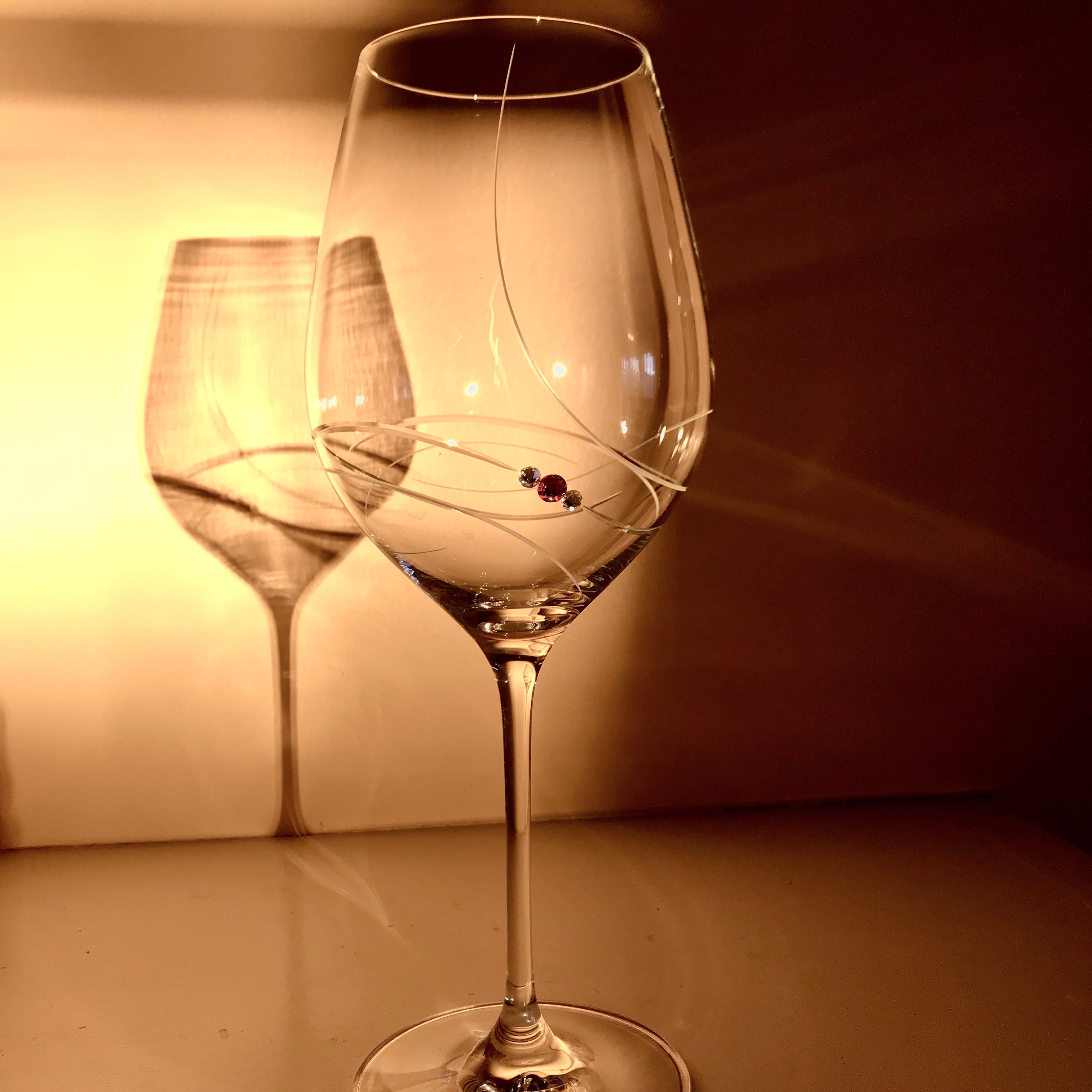 Set of two elegant pink ribbon red wine glasses with Swarovski crystals in a gift box, showcasing handcrafted lead-free crystal design.