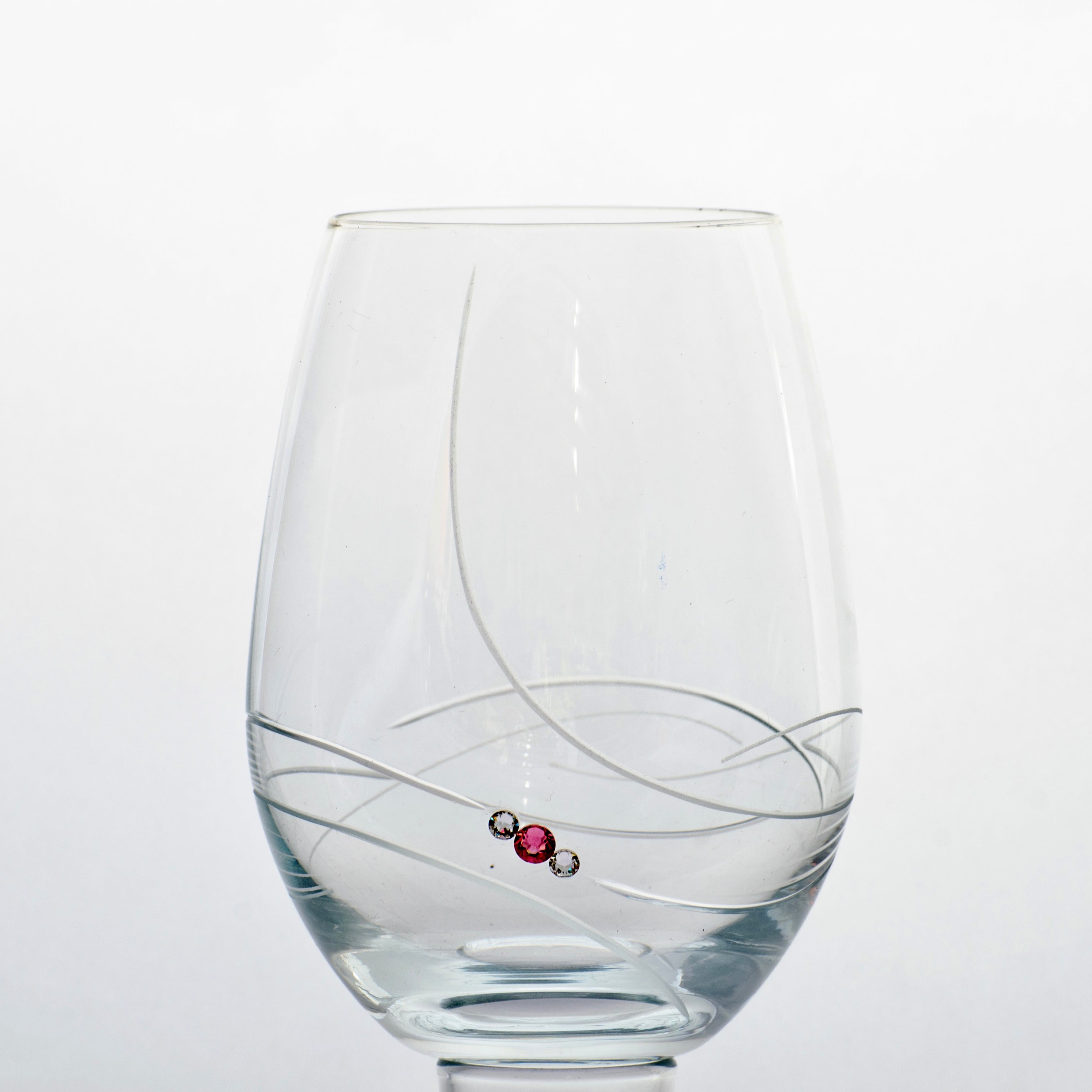 Set of two elegant pink ribbon stemless wine glasses with Swarovski crystals in a gift box, showcasing exquisite craftsmanship.