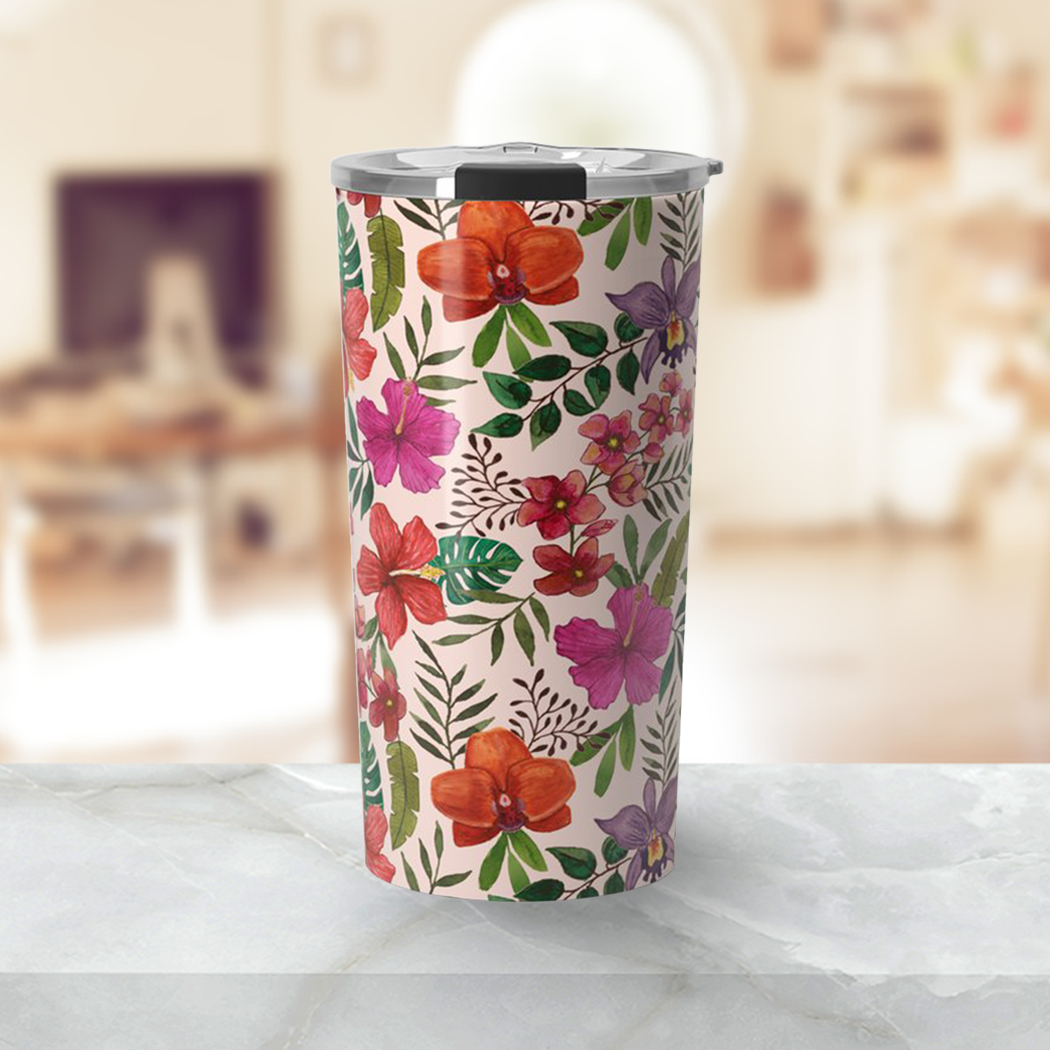 A vibrant pink travel mug featuring a tropical flower design, made of stainless steel with a double-wall for insulation.