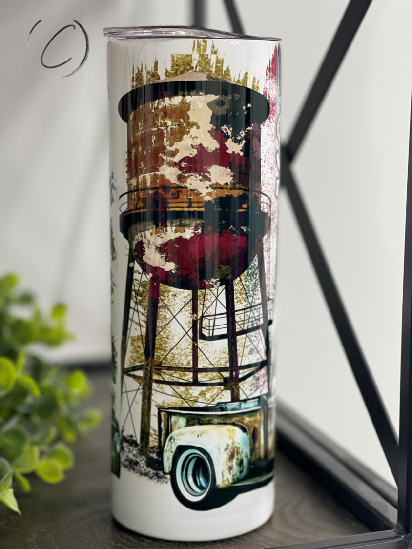 Small Town Girl Water Tower 20oz Skinny Tumbler with a charming water tower design, featuring a reusable straw.