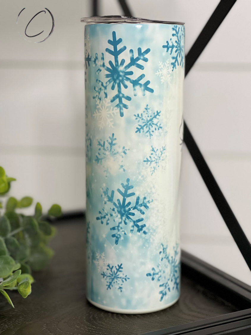 Snowflake Snowman 20oz UV Blue Skinny Tumbler with color-changing effect in sunlight, featuring a whimsical snowman design.