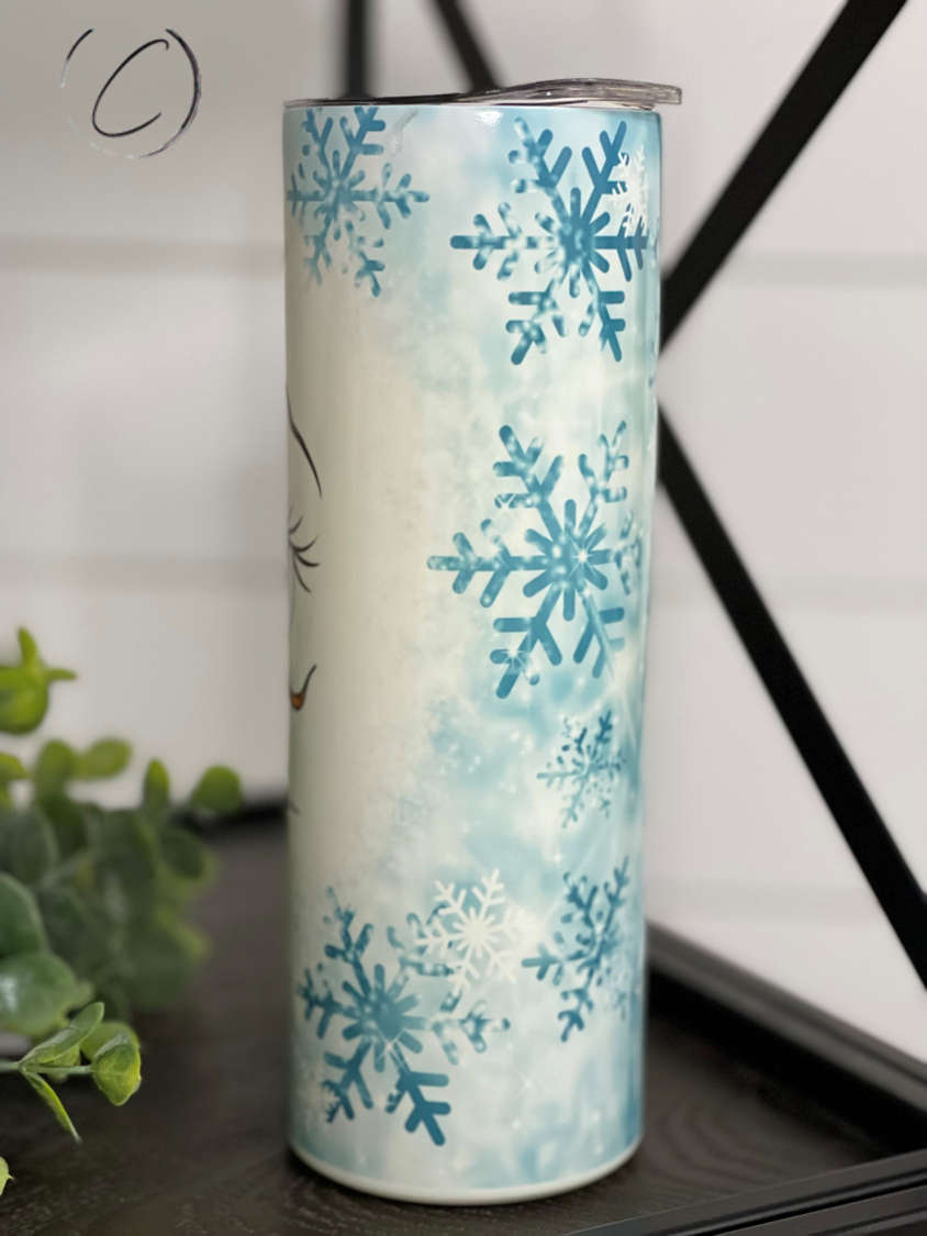 Snowflake Snowman 20oz UV Blue Skinny Tumbler with color-changing effect in sunlight, featuring a whimsical snowman design.