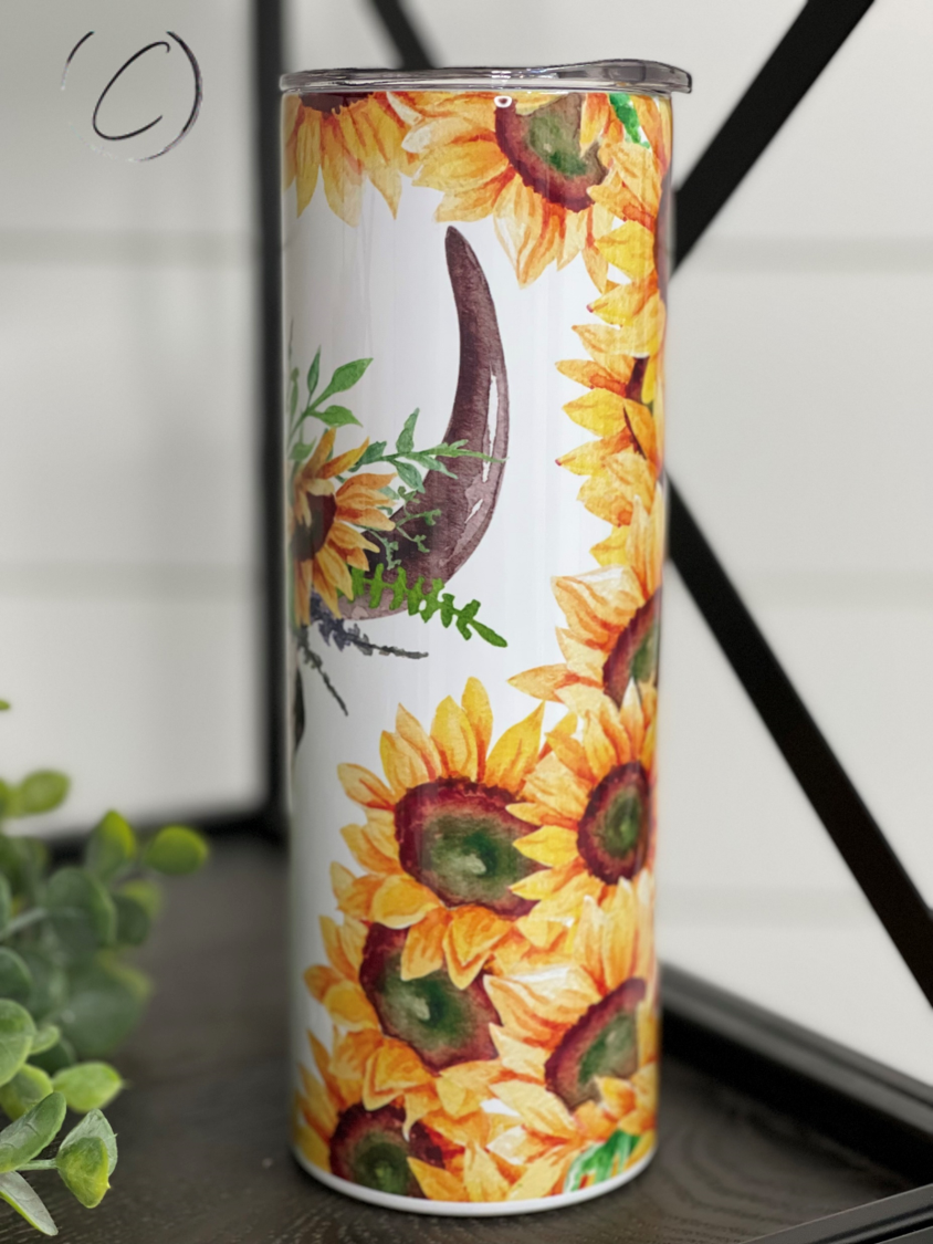 A stylish 20oz skinny tumbler featuring a sunflower and bull skull design, perfect for hot and cold beverages.