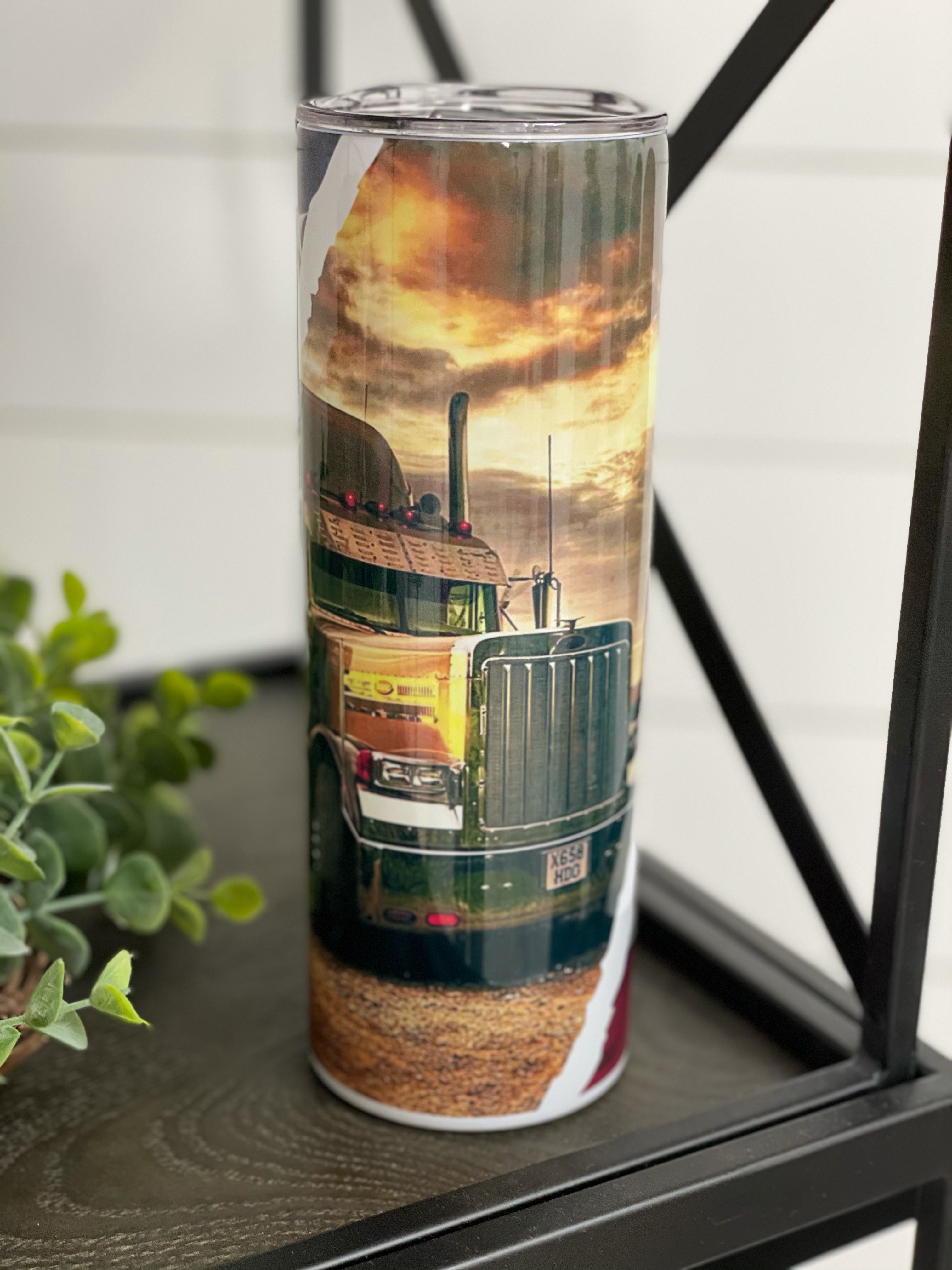 Trucker 20oz Skinny Tumbler with vibrant full wrap design and reusable straw, showcasing its high-quality construction.