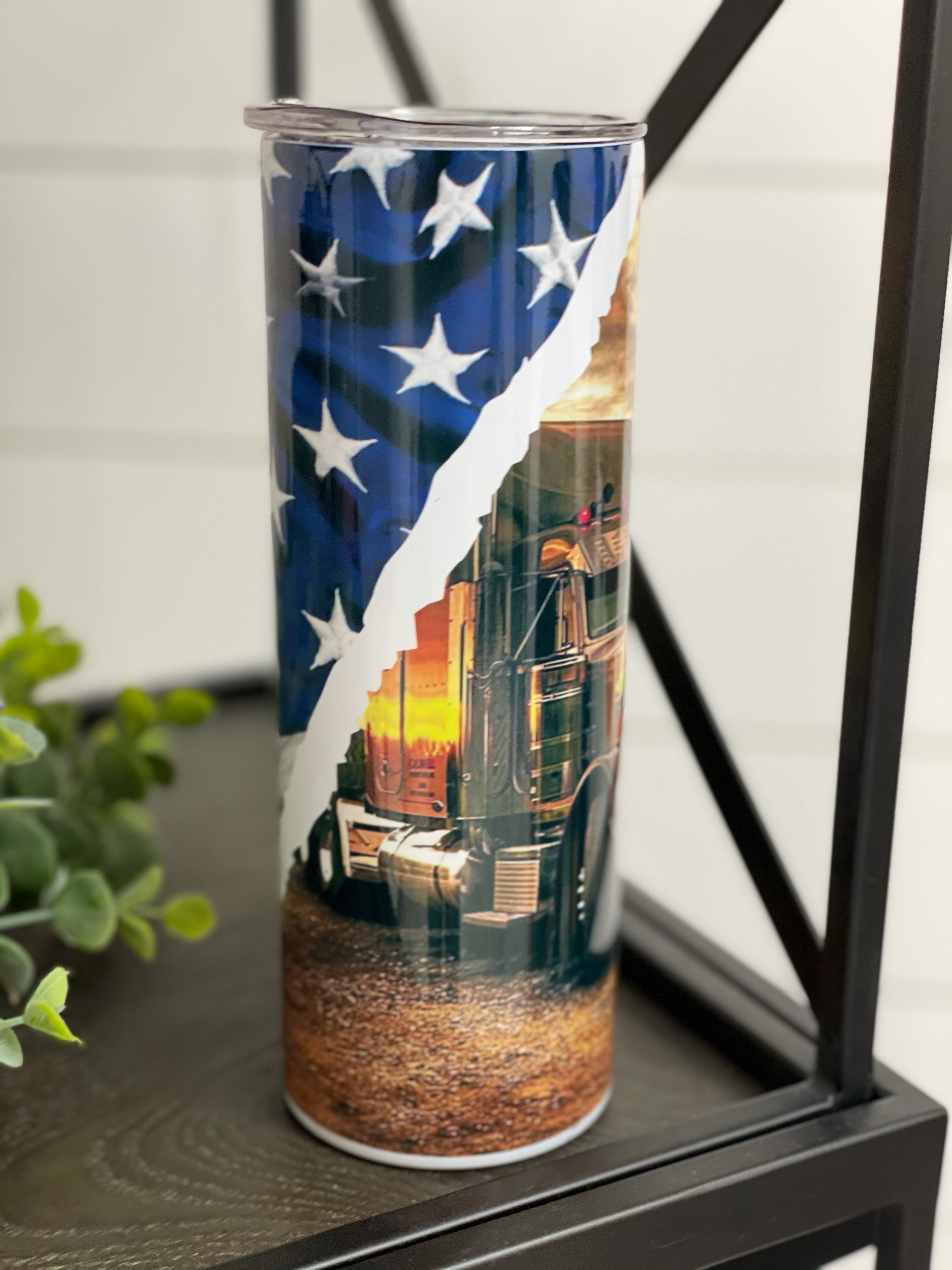 Trucker 20oz Skinny Tumbler with vibrant full wrap design and reusable straw, showcasing its high-quality construction.