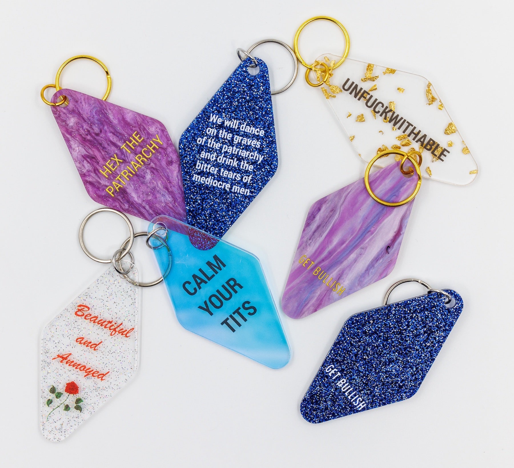 Clear keychain with gold leaf accents and gold hardware, featuring the text 'UNFUCKWITHABLE'.