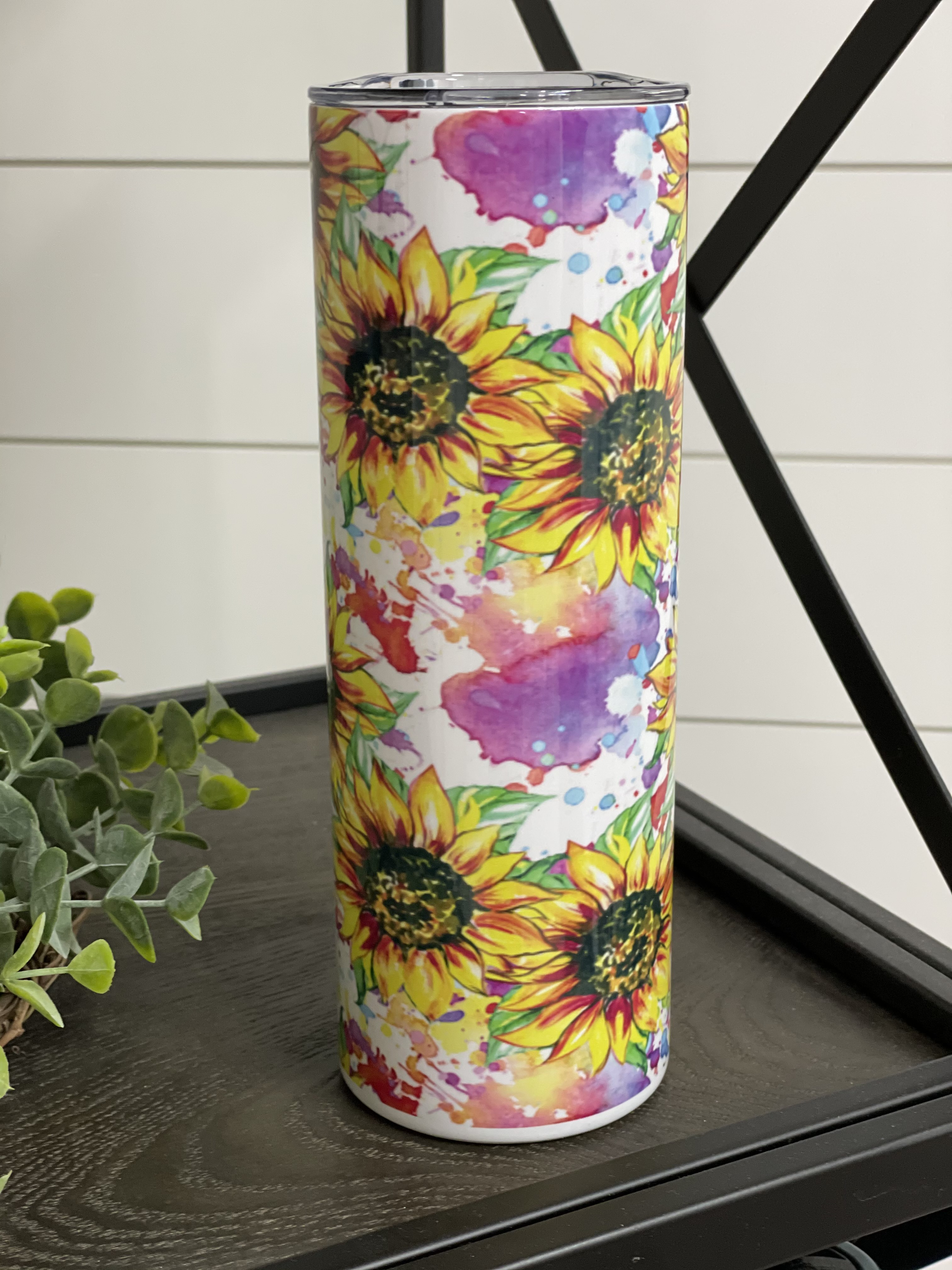 A 20oz skinny tumbler featuring a vibrant water color sunflower design, perfect for drinks on the go.