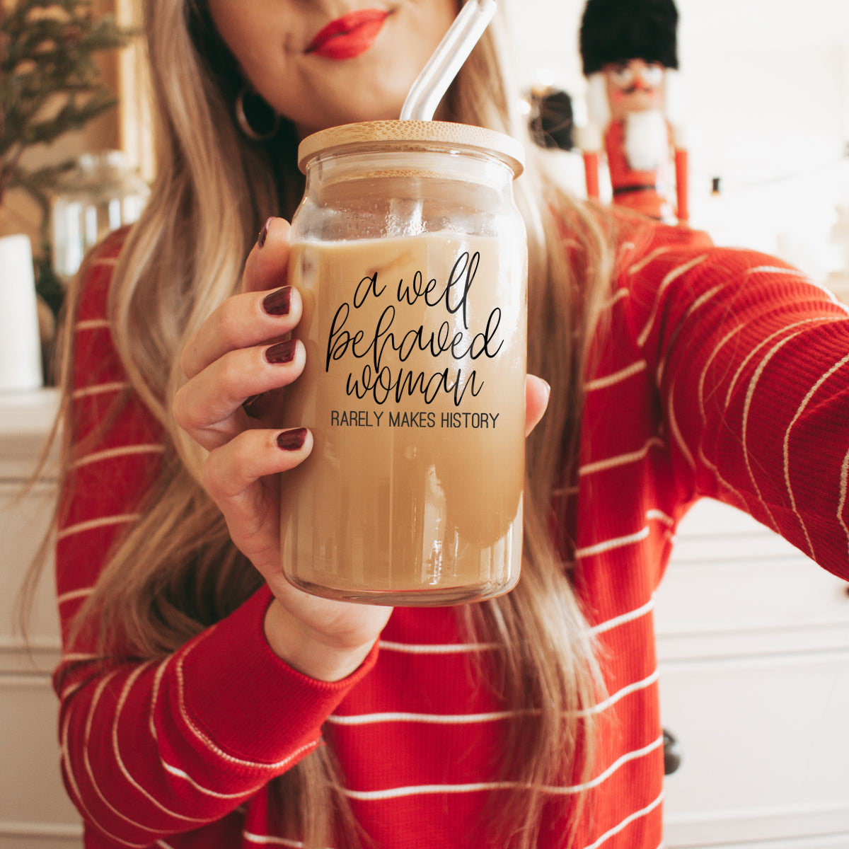 Well Behaved Woman Glass Cup with bamboo lid and stainless steel straws, showcasing a stylish black graphic design.