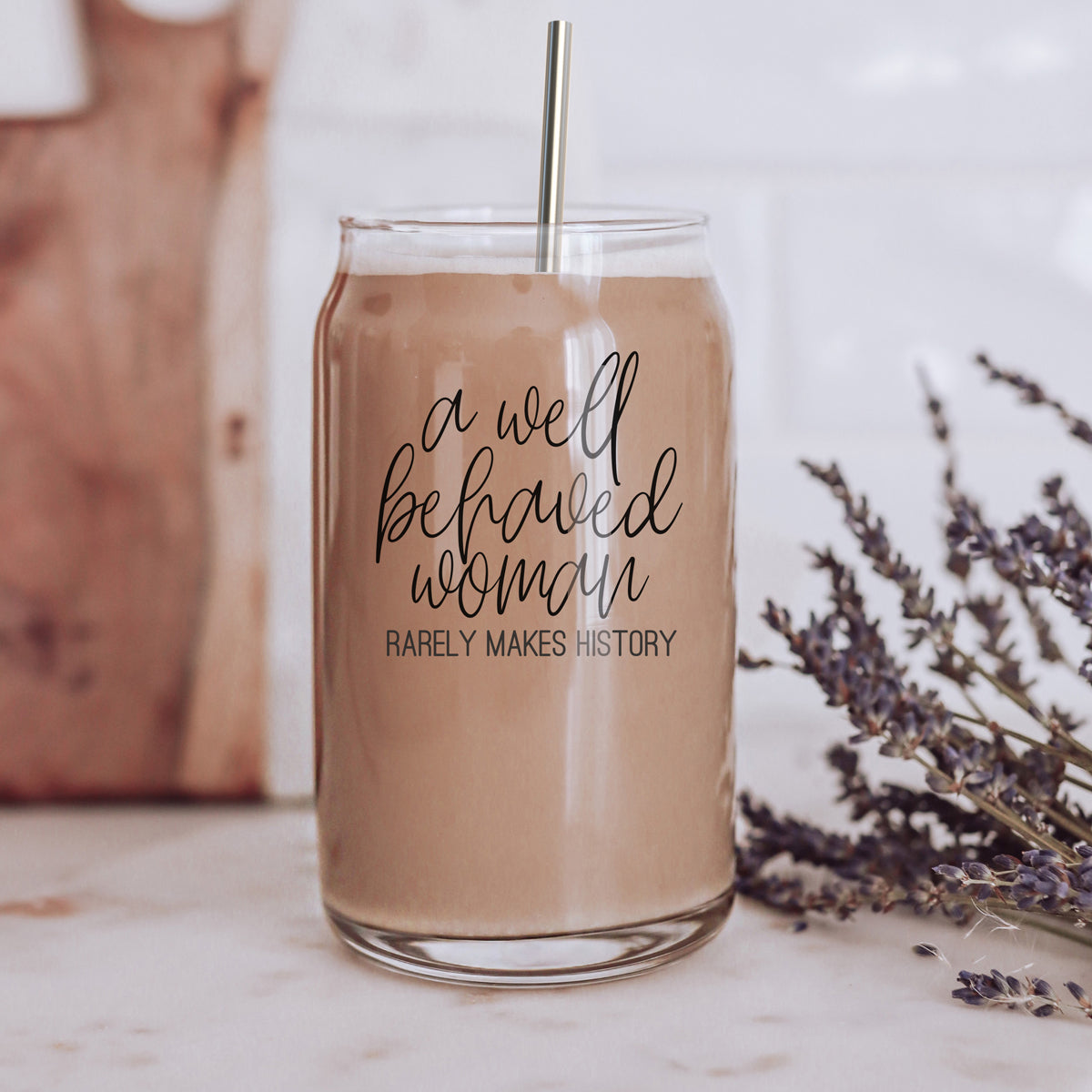 Well Behaved Woman Glass Cup with bamboo lid and stainless steel straws, showcasing a stylish black graphic design.