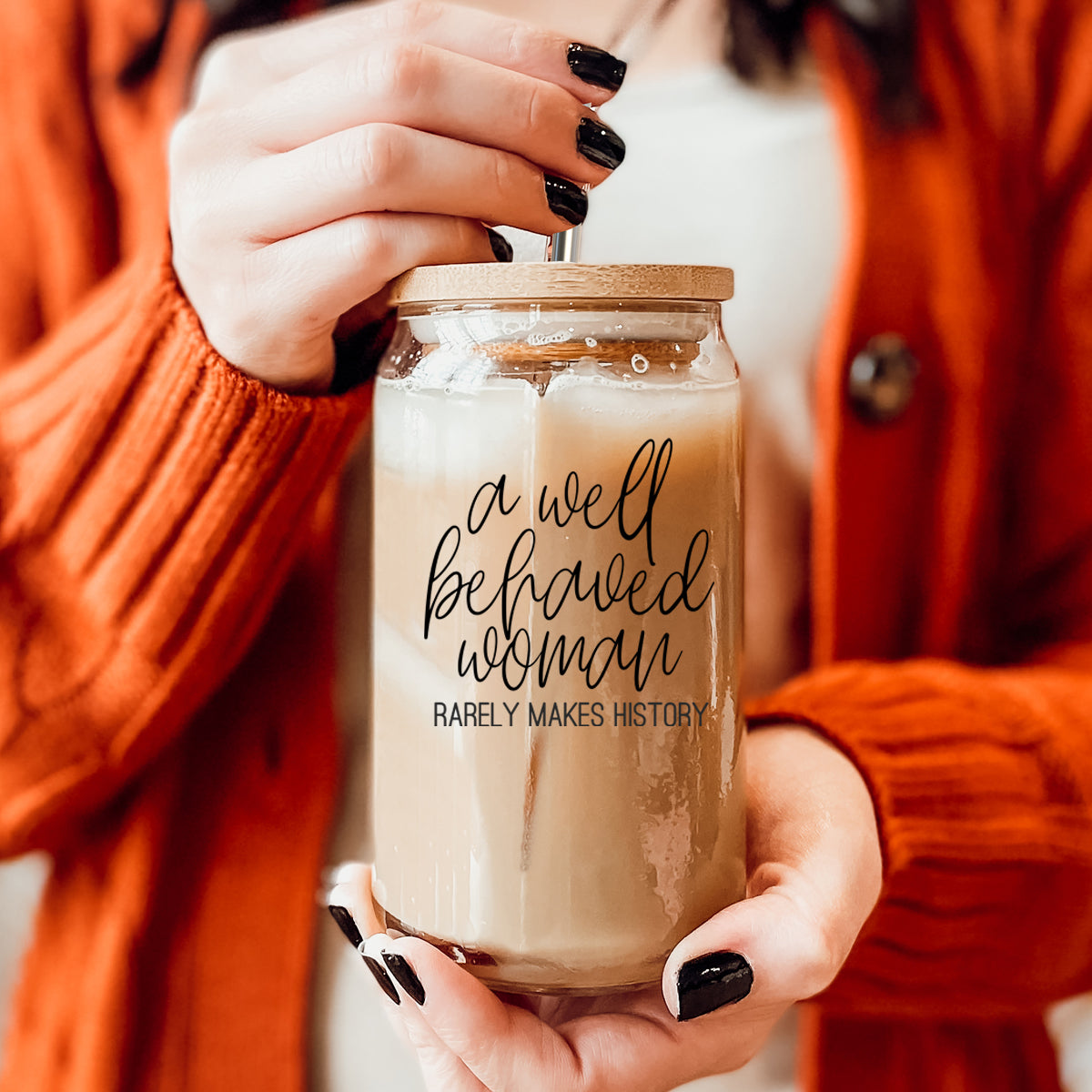 Well Behaved Woman Glass Cup with bamboo lid and stainless steel straws, showcasing a stylish black graphic design.