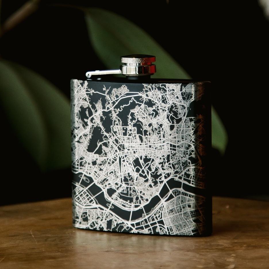 Custom engraved matte black hip flask featuring a detailed map of Zion National Park, Utah, with coordinates, accompanied by a canvas bag and funnel.