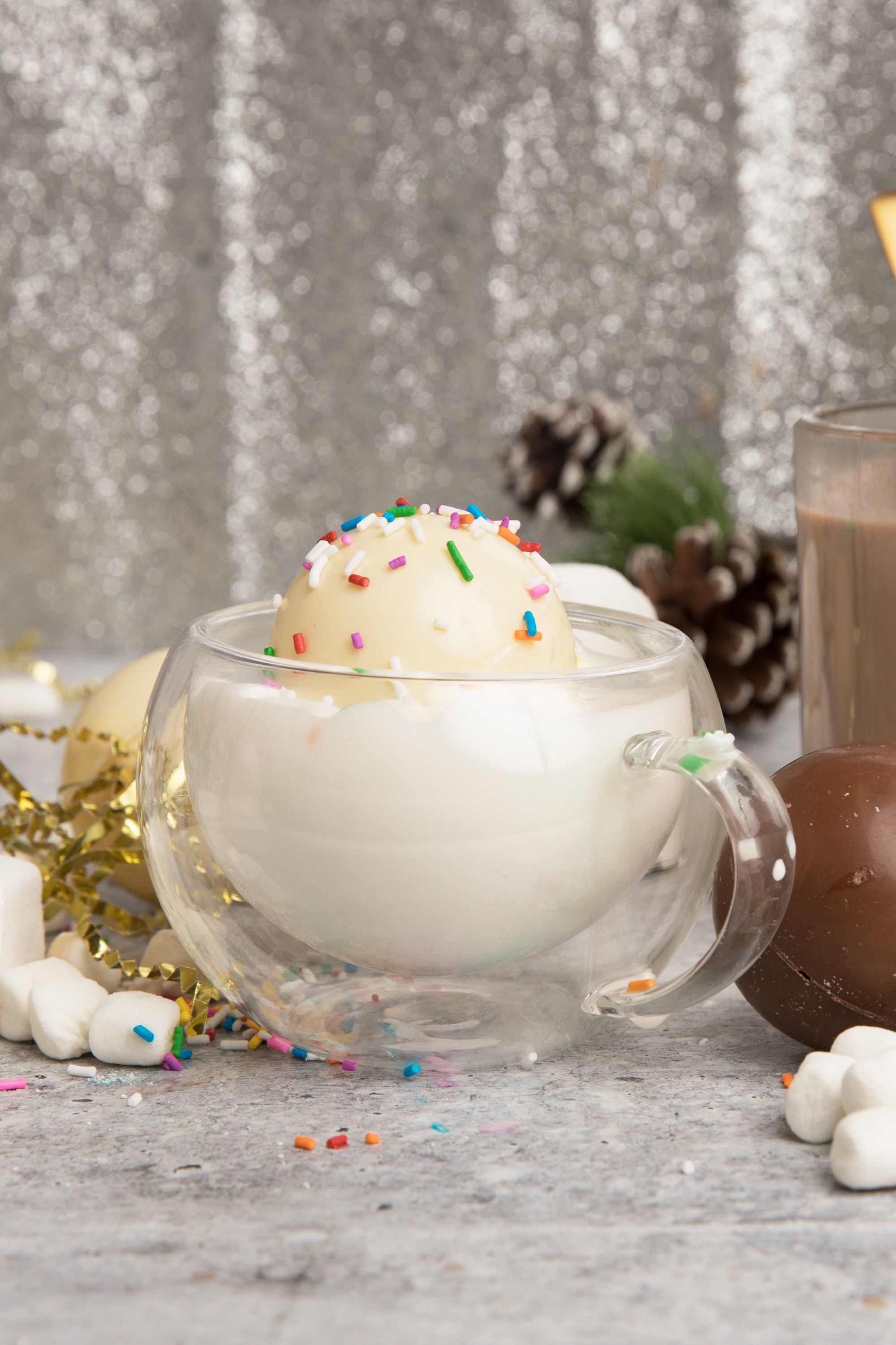 Three white chocolate cocoa bombs with mini marshmallows, beautifully arranged for a delightful hot cocoa experience.