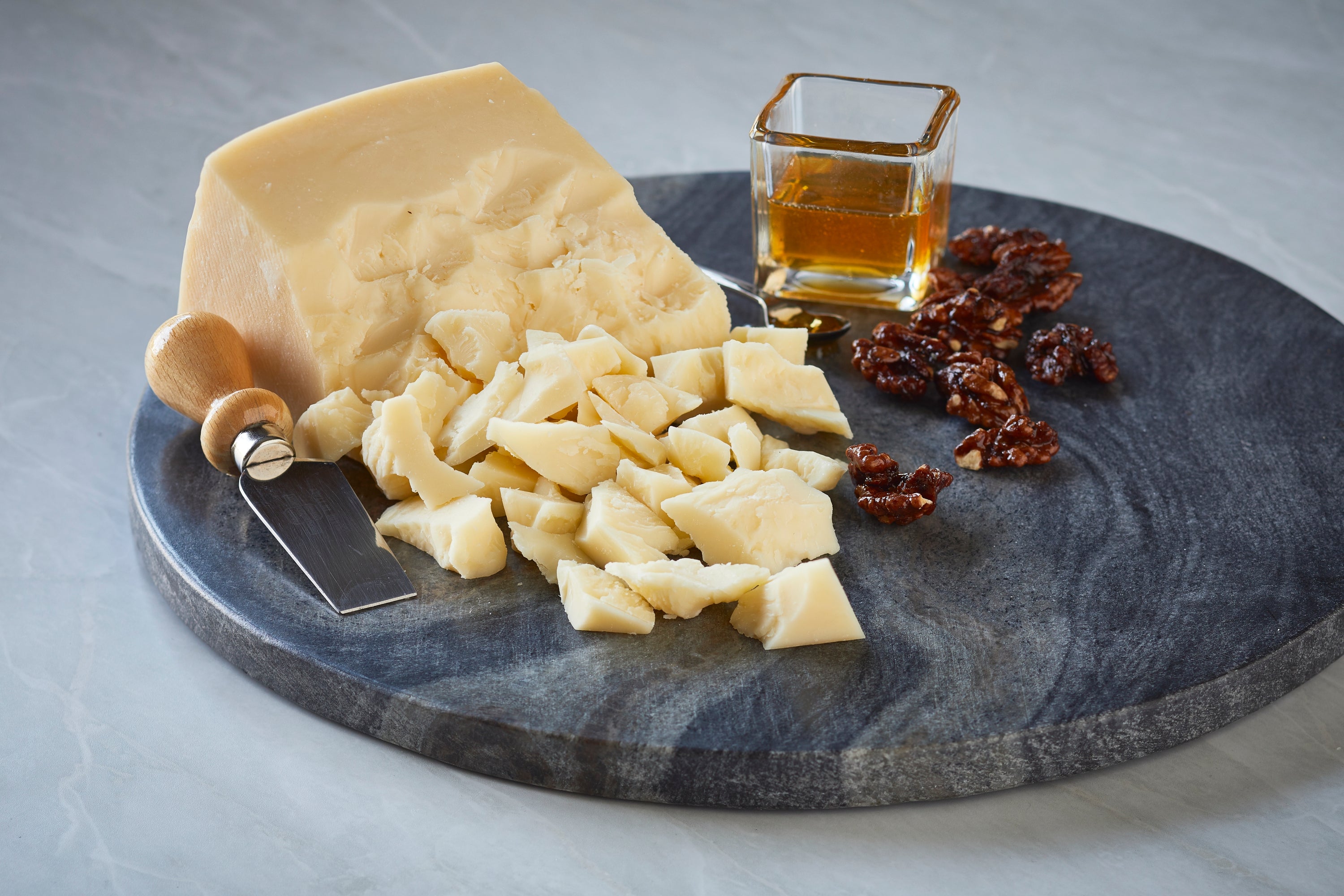 A block of Asiago cheese showcasing its semi-hard texture and rich color, perfect for grating or serving on a cheese platter.