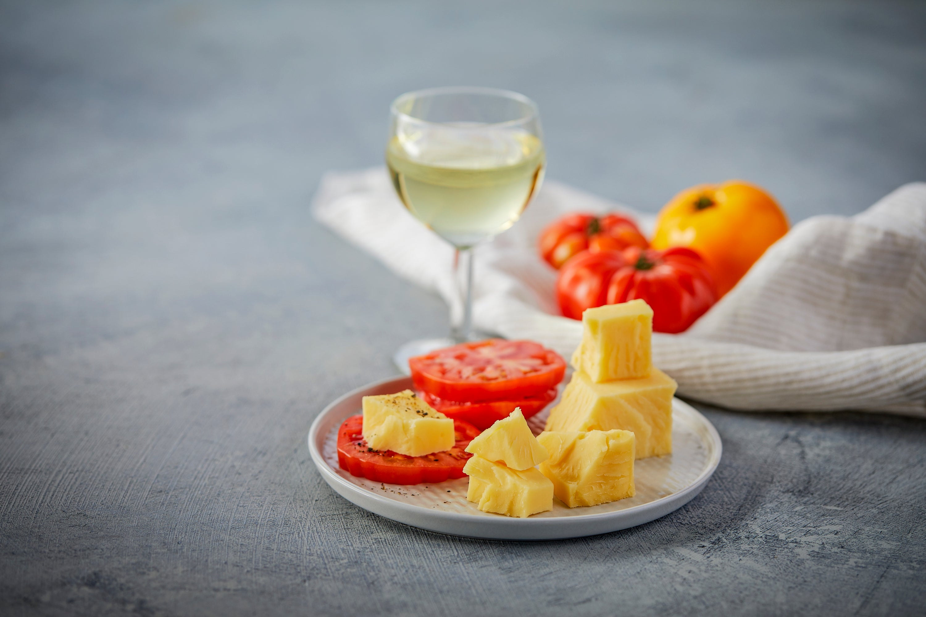 A block of Asiago cheese showcasing its semi-hard texture and rich color, perfect for grating or serving on a cheese platter.