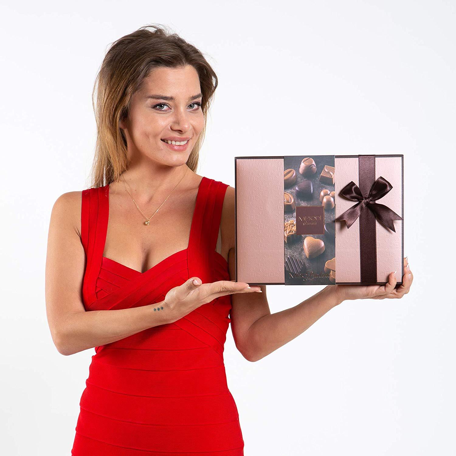 A beautifully arranged box of assorted chocolate truffles featuring various flavors including milk, dark, and white chocolates, elegantly packaged for gifting.