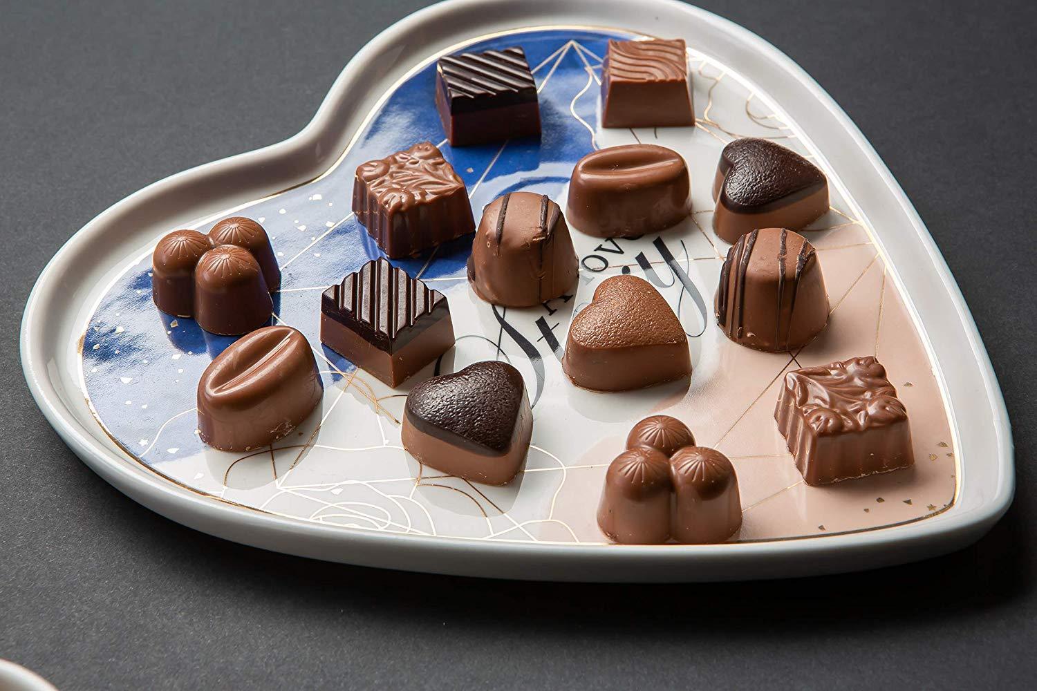 A beautifully arranged box of assorted chocolate truffles featuring various flavors including milk, dark, and white chocolates, elegantly packaged for gifting.