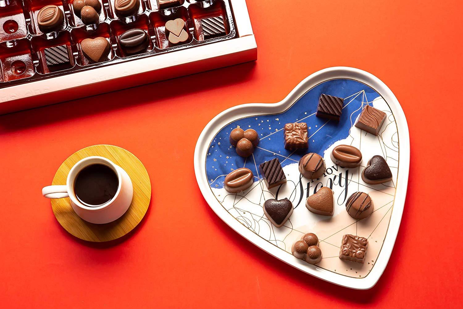 A beautifully arranged box of assorted chocolate truffles featuring various flavors including milk, dark, and white chocolates, elegantly packaged for gifting.