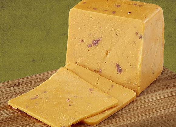 A block of Bacon Cheddar cheese with real bacon bits, showcasing its firm and slightly crumbly texture.