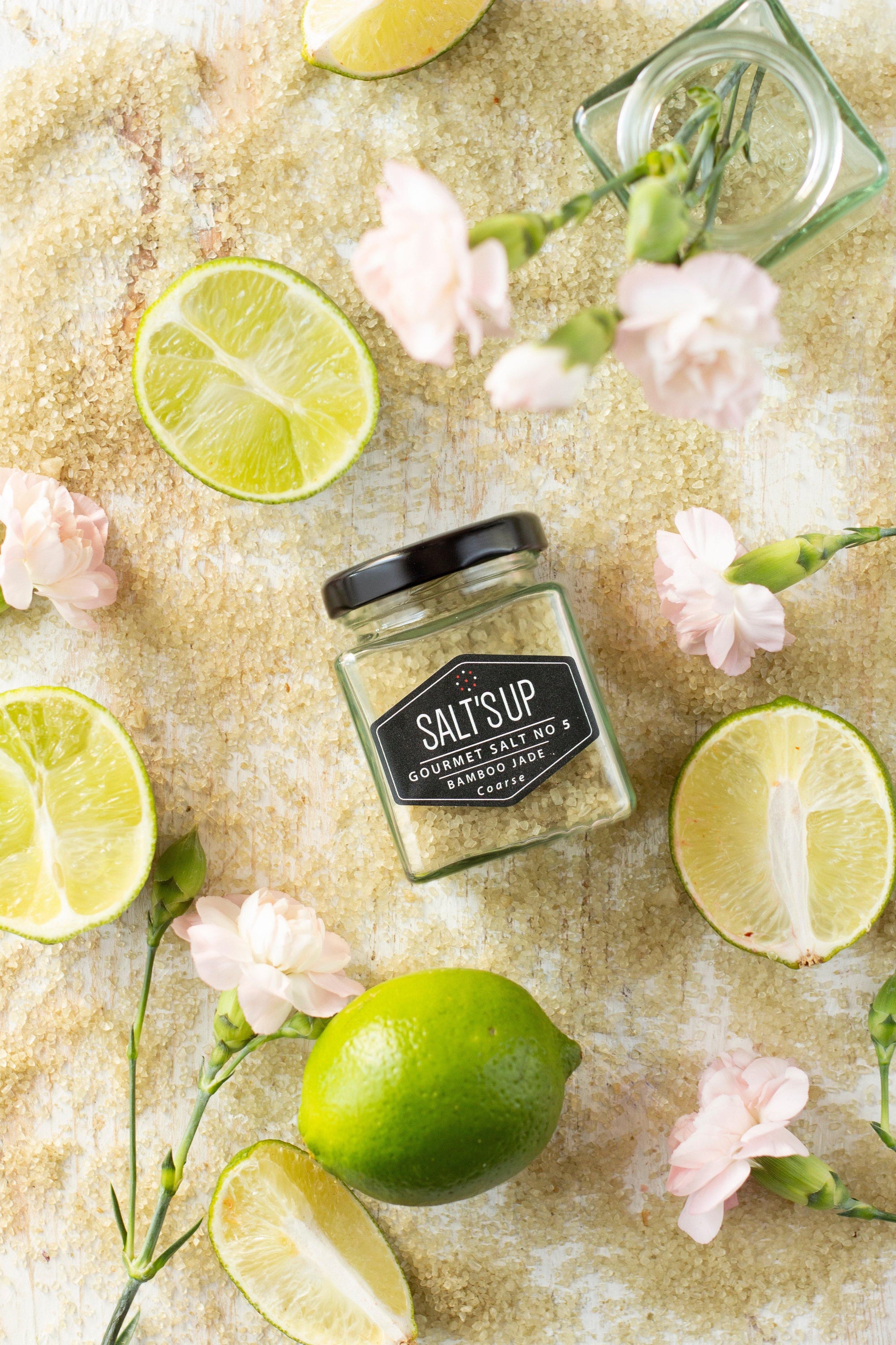 A jar of BAMBOO JADE coarse salt showcasing its fine crystals and organic bamboo leaf extract, perfect for enhancing Asian cuisine.