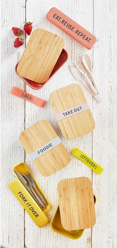 Three eco-friendly bamboo lunch boxes in pastel blue, vivid yellow, and blush pink, stacked together with bamboo wood lids.