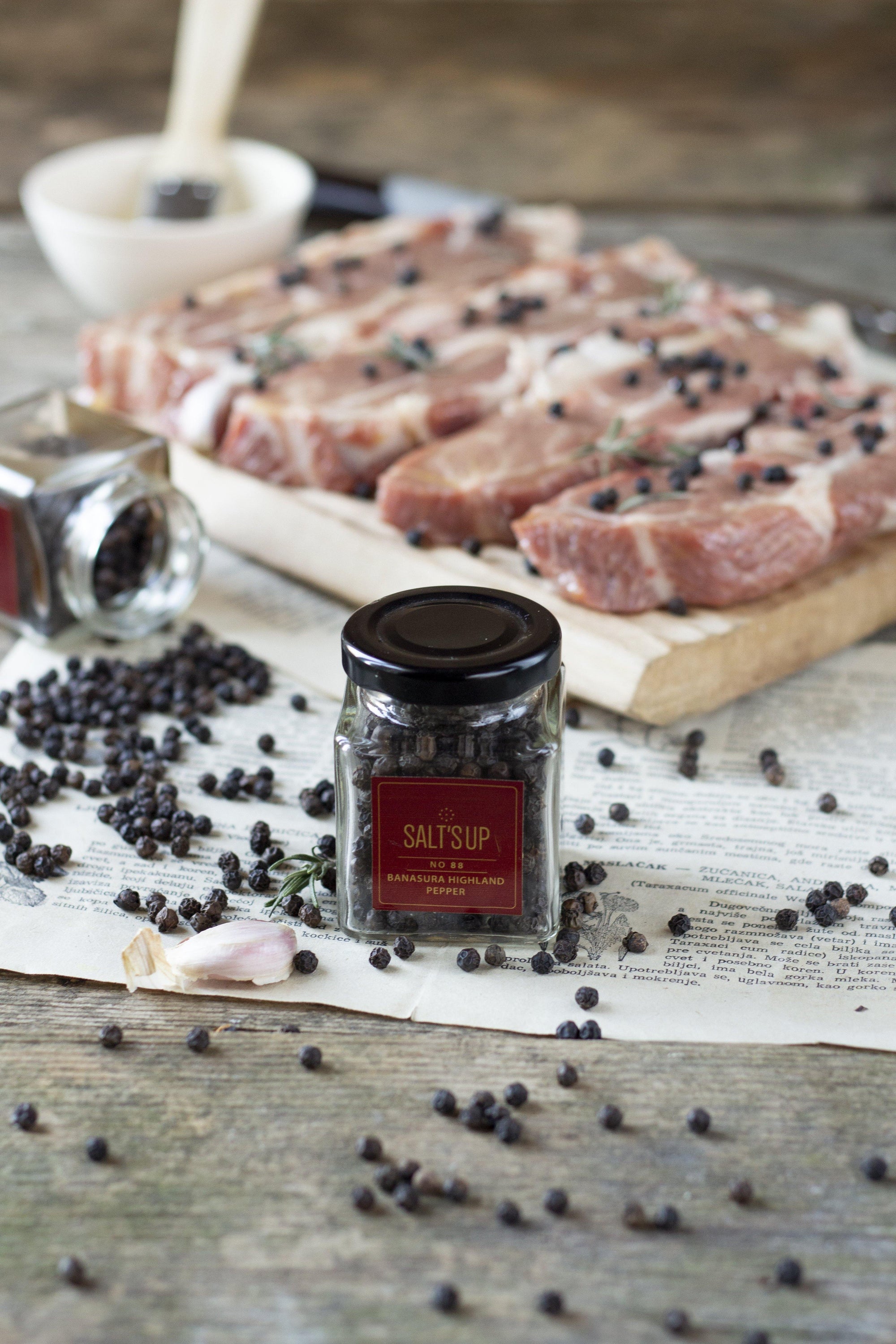 A glass jar containing Banasura Highland pepper, showcasing its rich, dark berries and elegant packaging.