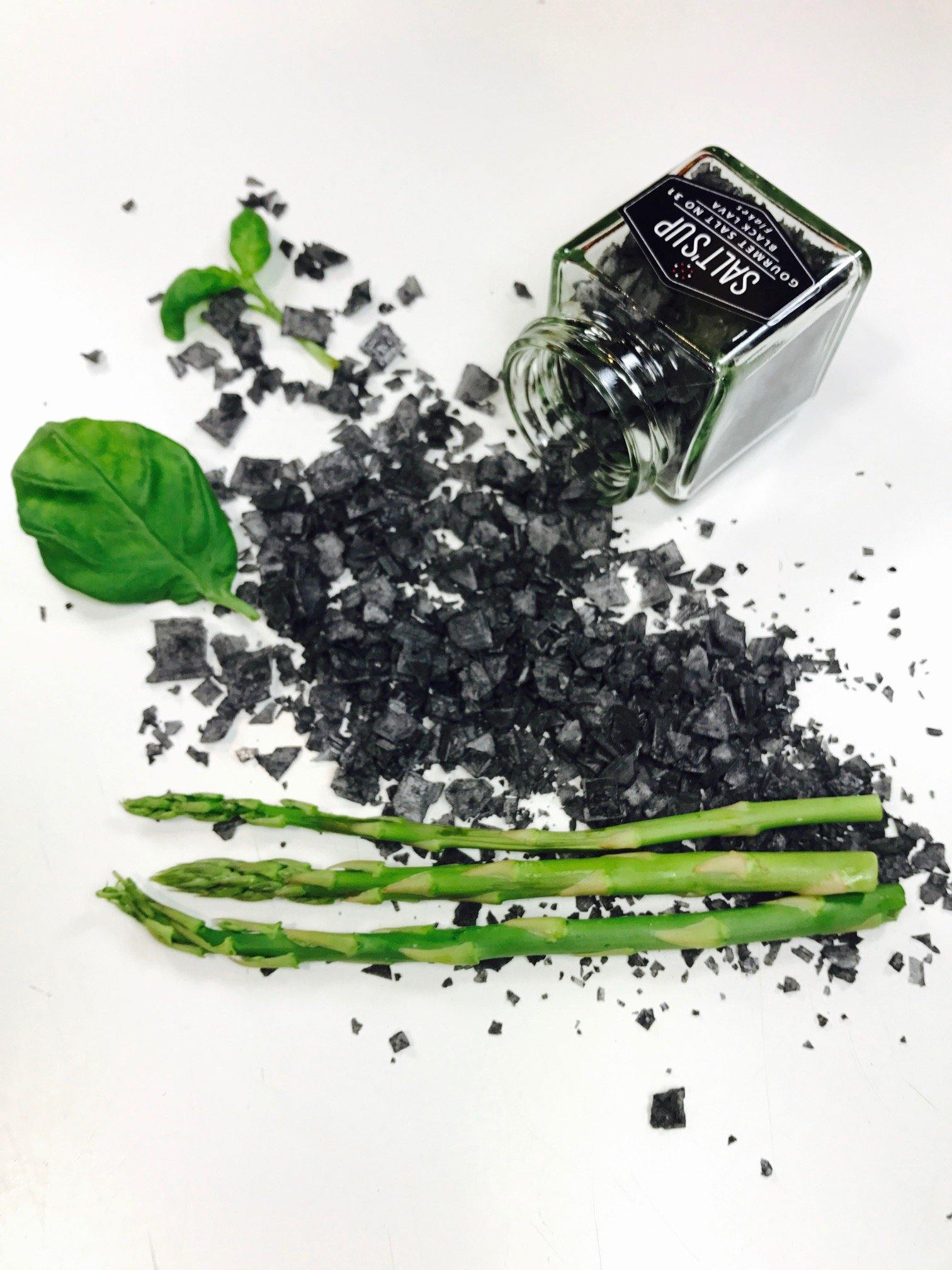 BLACK LAVA salt flakes in an ecopack, showcasing its dramatic black color and fine texture, perfect for gourmet cooking.