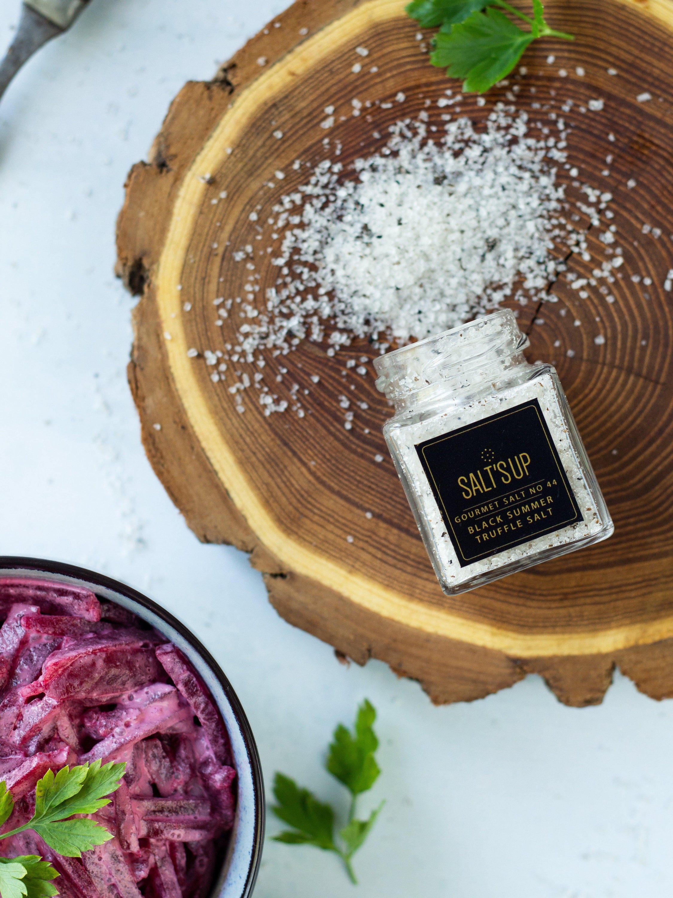 A glass jar of Black Summer Truffle salt showcasing its rich texture and truffle pieces, perfect for gourmet cooking.