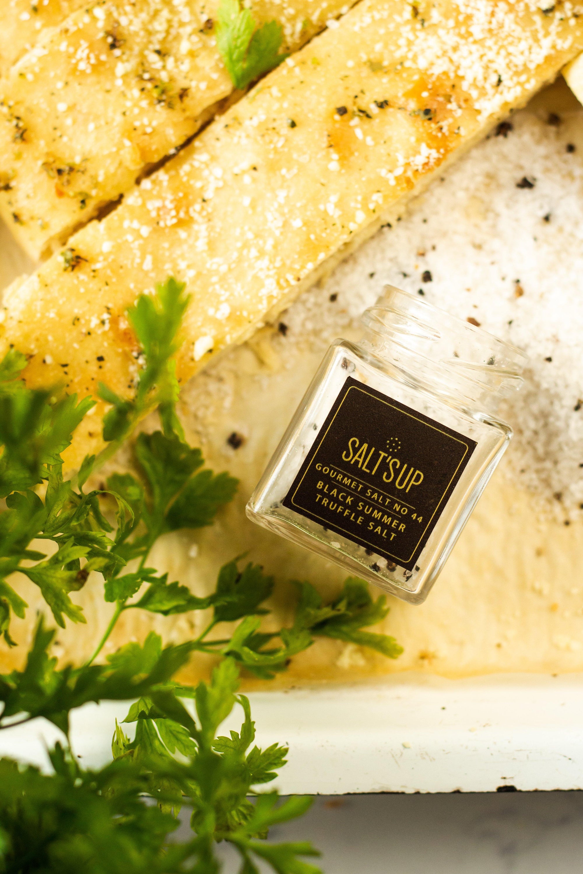 A glass jar of Black Summer Truffle salt showcasing its rich texture and truffle pieces, perfect for gourmet cooking.