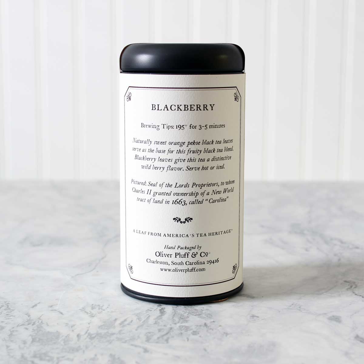 A stylish matte black tea tin filled with Blackberry Teabags, showcasing elegant packaging and a rich tea blend.