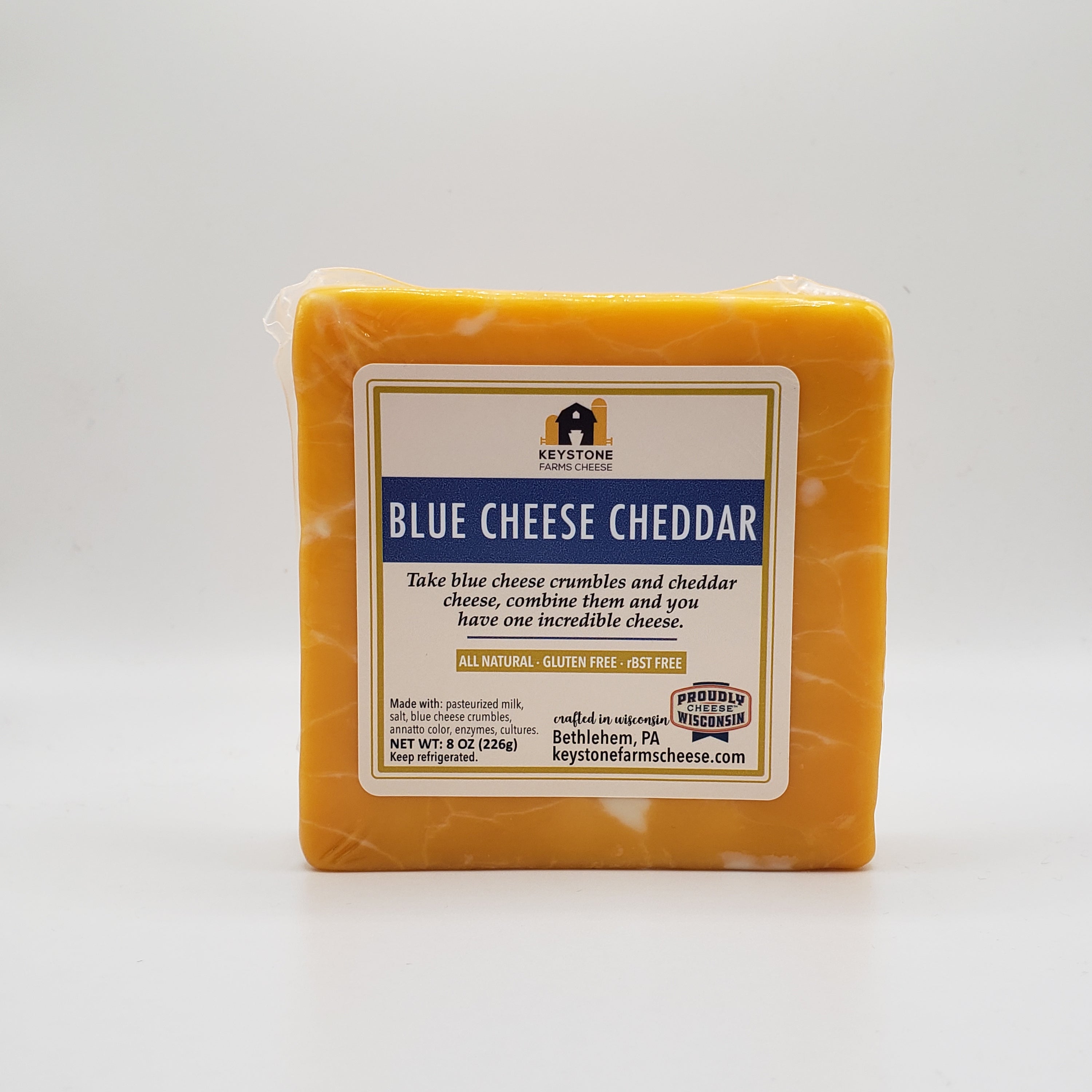 A close-up of Blue Cheese Cheddar cheese, showcasing its marbled texture of blue cheese crumbles and creamy cheddar.