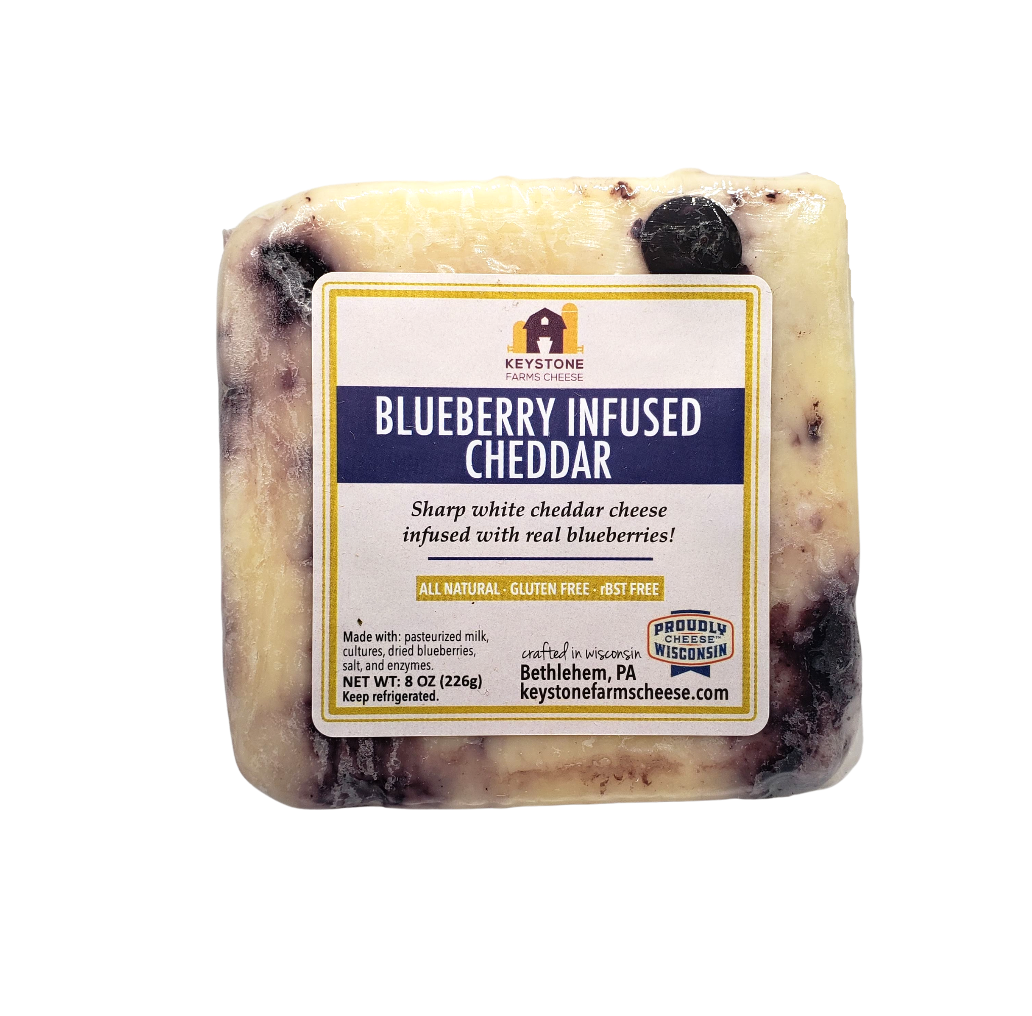 A wedge of Blueberry Infused Cheddar cheese showcasing its creamy texture and visible blueberry pieces, served on a wooden cheese board.