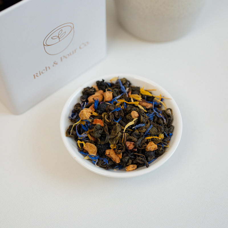 A vibrant package of Blueberry Pie Green Tea Blend featuring blueberry and apple pieces, showcasing its rich flavor profile.