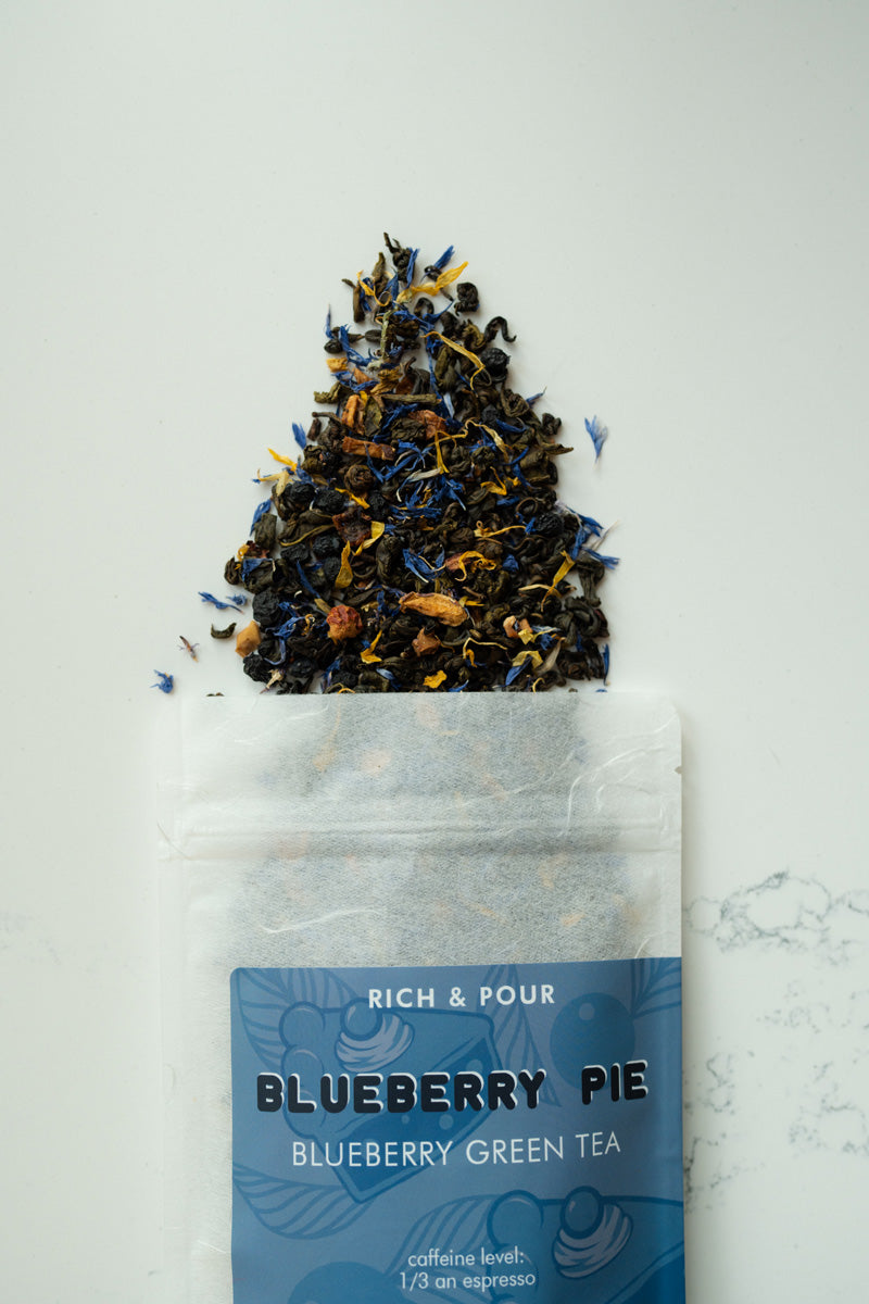 A vibrant package of Blueberry Pie Green Tea Blend featuring blueberry and apple pieces, showcasing its rich flavor profile.