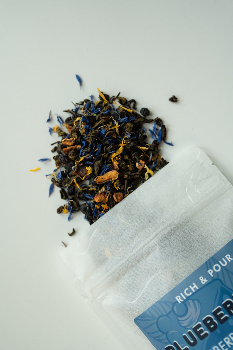 A vibrant package of Blueberry Pie Green Tea Blend featuring blueberry and apple pieces, showcasing its rich flavor profile.