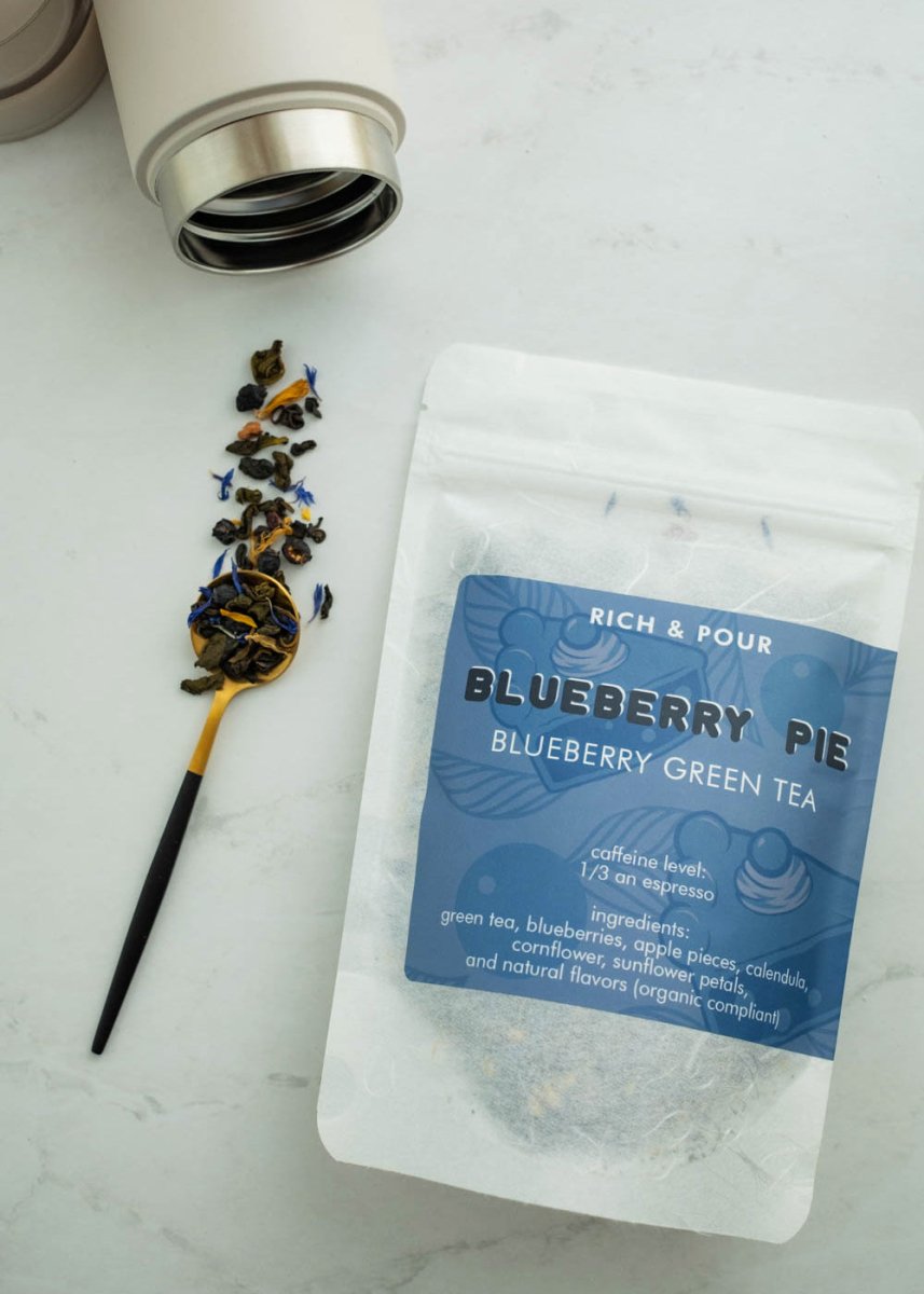 A vibrant package of Blueberry Pie Green Tea Blend featuring blueberry and apple pieces, showcasing its rich flavor profile.