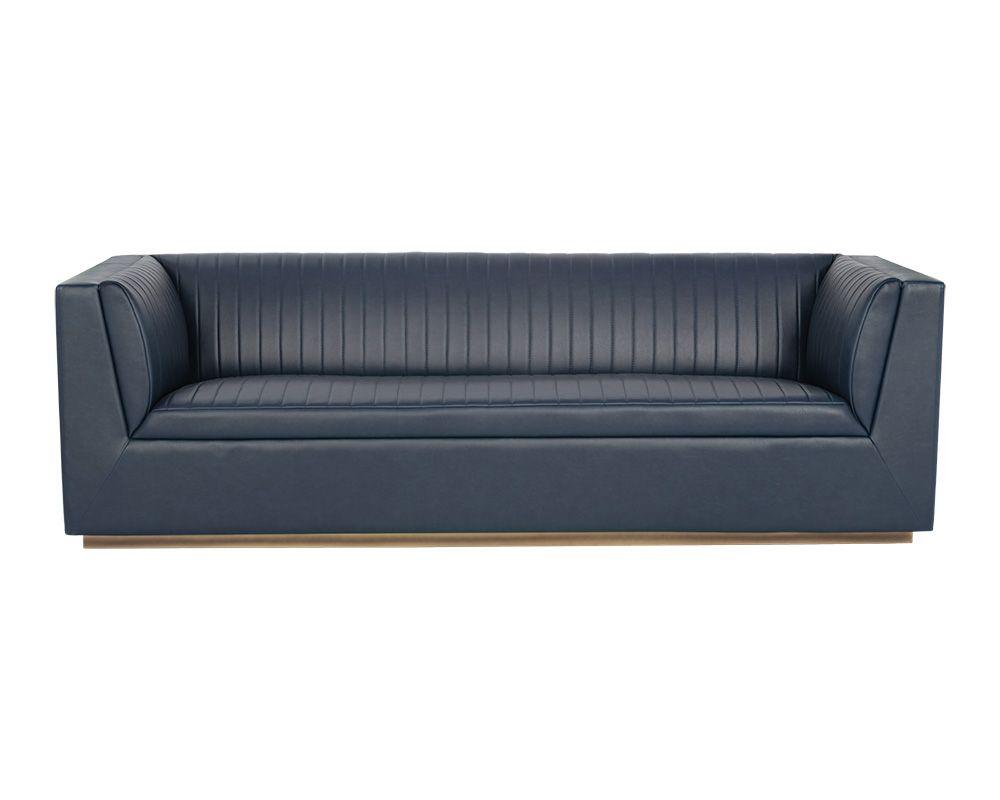 The Bradley Sofa featuring channel tufting in vintage blue faux leather with rustic bronze steel legs.