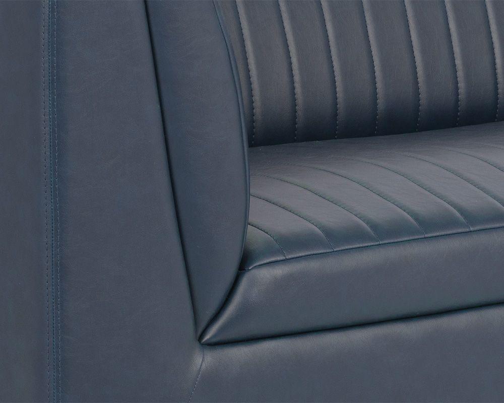 The Bradley Sofa featuring channel tufting in vintage blue faux leather with rustic bronze steel legs.