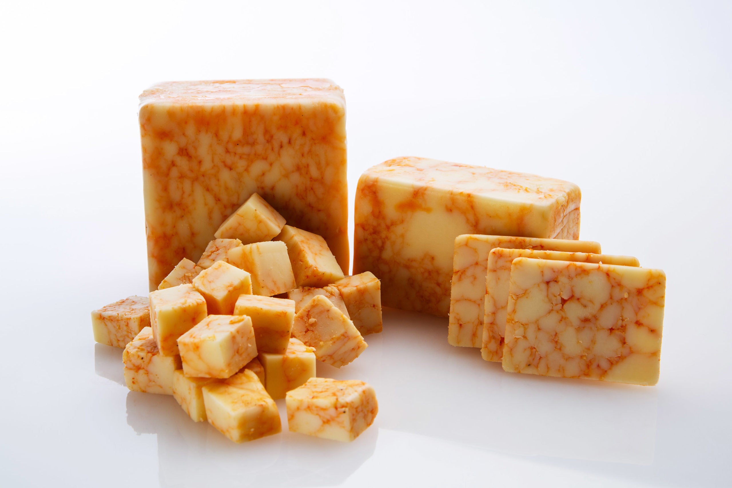 Buffalo Cheddar cheese block infused with buffalo wing sauce, showcasing its creamy texture and vibrant color.