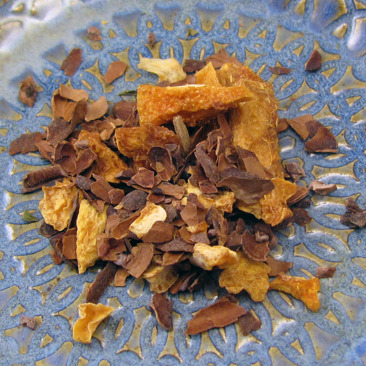 A tin of Martha Washington's Cacao Citrus Tea containing loose roasted cacao shells and dried citrus peels, showcasing a rich blend of flavors.