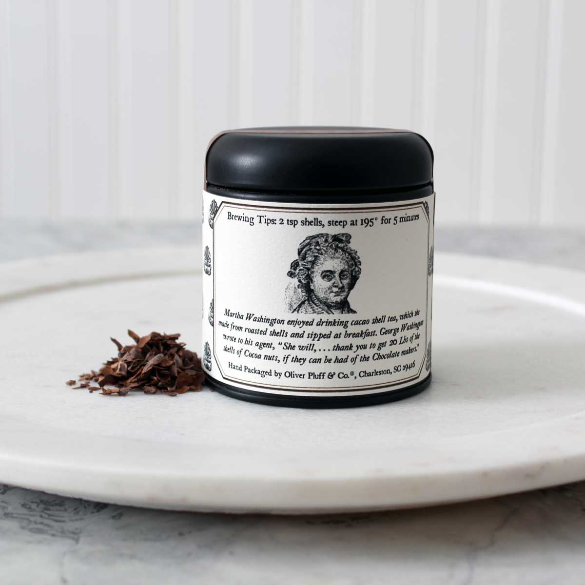 A tin of Martha Washington's Cacao Shell Tea containing loose roasted cacao shells, showcasing its rich chocolatey essence.